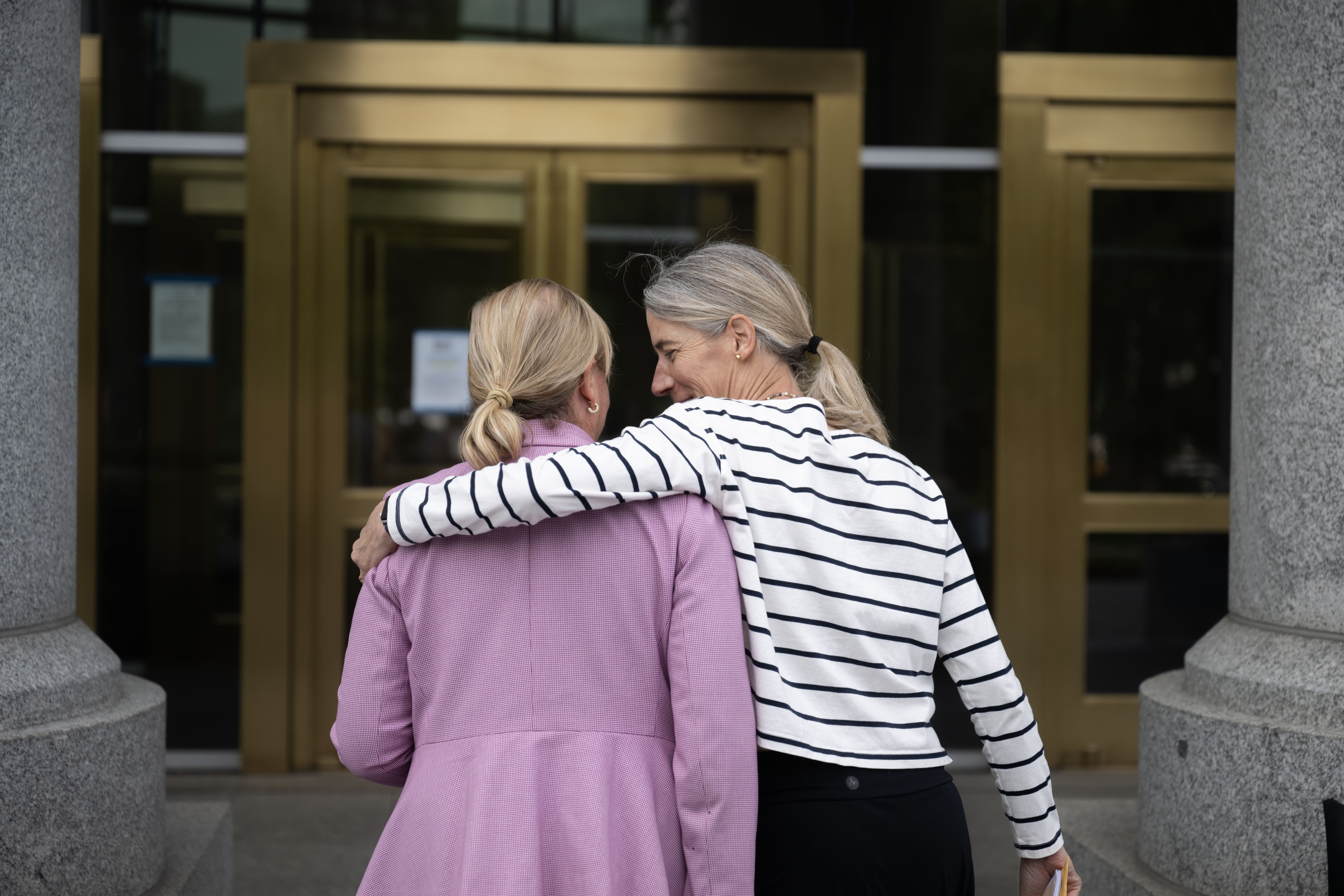 Christine McGinley, right, puts her arm around State Representative Meg Froelich as they walk into the Ralph L. Carr Colorado Justice Center in Denver following a rally calling for family court reforms outside the Ralph L. Carr Justice Center in Denver on Thursday, Sept. 5, 2024. (Stephen Swofford, Denver Gazette) (Stephen Swofford Denver Gazette)
