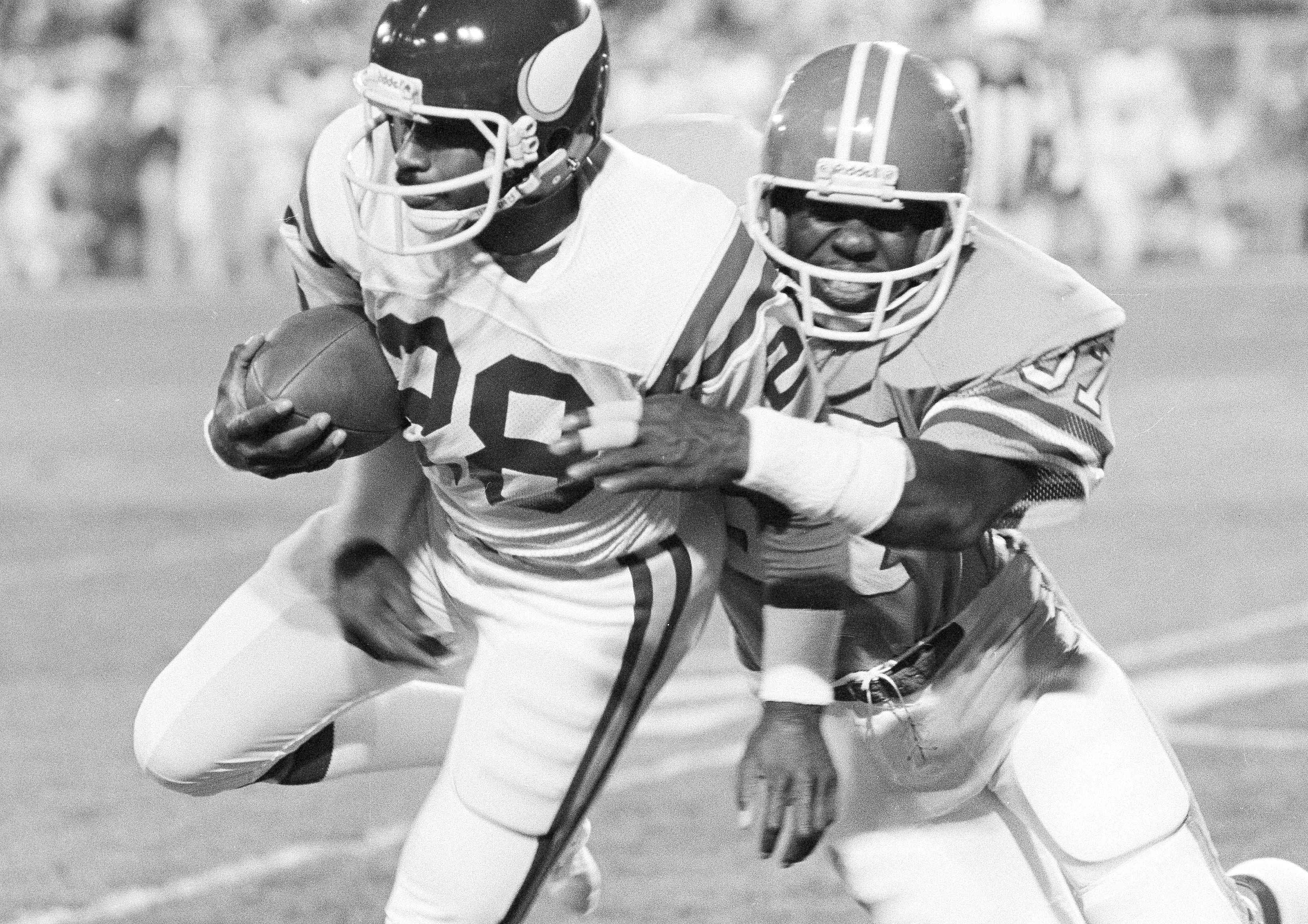 Minnesota Vikings wide receiver Ahmad Rashad (28) is wrapped up by the Denver Broncos defender Tom Jackson (57) after Rashad pulled in a pass from his quarterback during first half action in their game at Denver's Mile High Stadium, Nov. 2, 1981. (AP Photo) (STR)