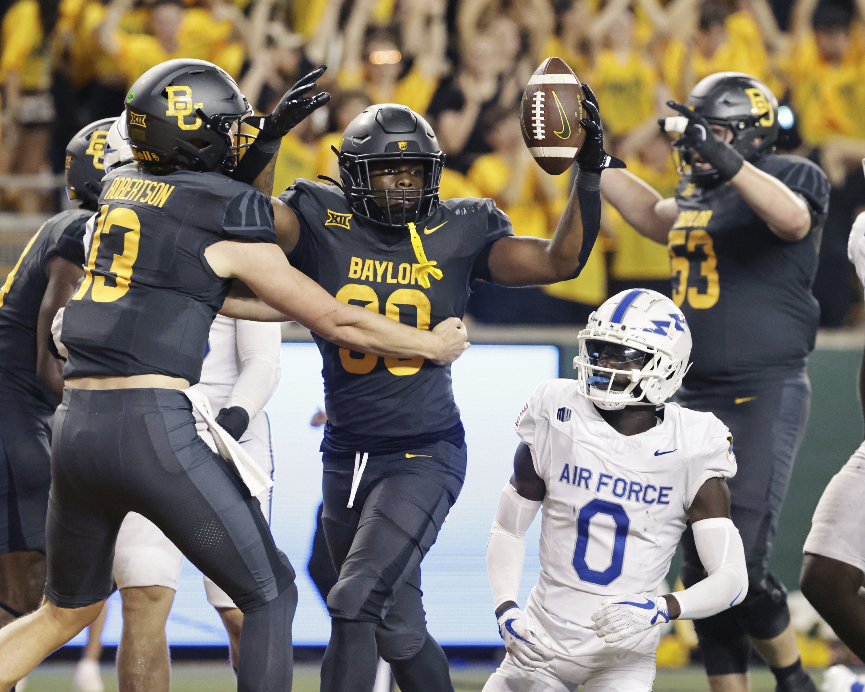 Baylor running back Bryson Washington, center, reacts with quarterback Sawyer Robertson, left, after scoring over Air Force defensive back Trey Williams (0) in the first second of an NCAA college football game, Saturday, Sept. 14, 2024, in Waco, Texas. (Jerry Larson/Waco Tribune-Herald, via AP) (Jerry Larson)