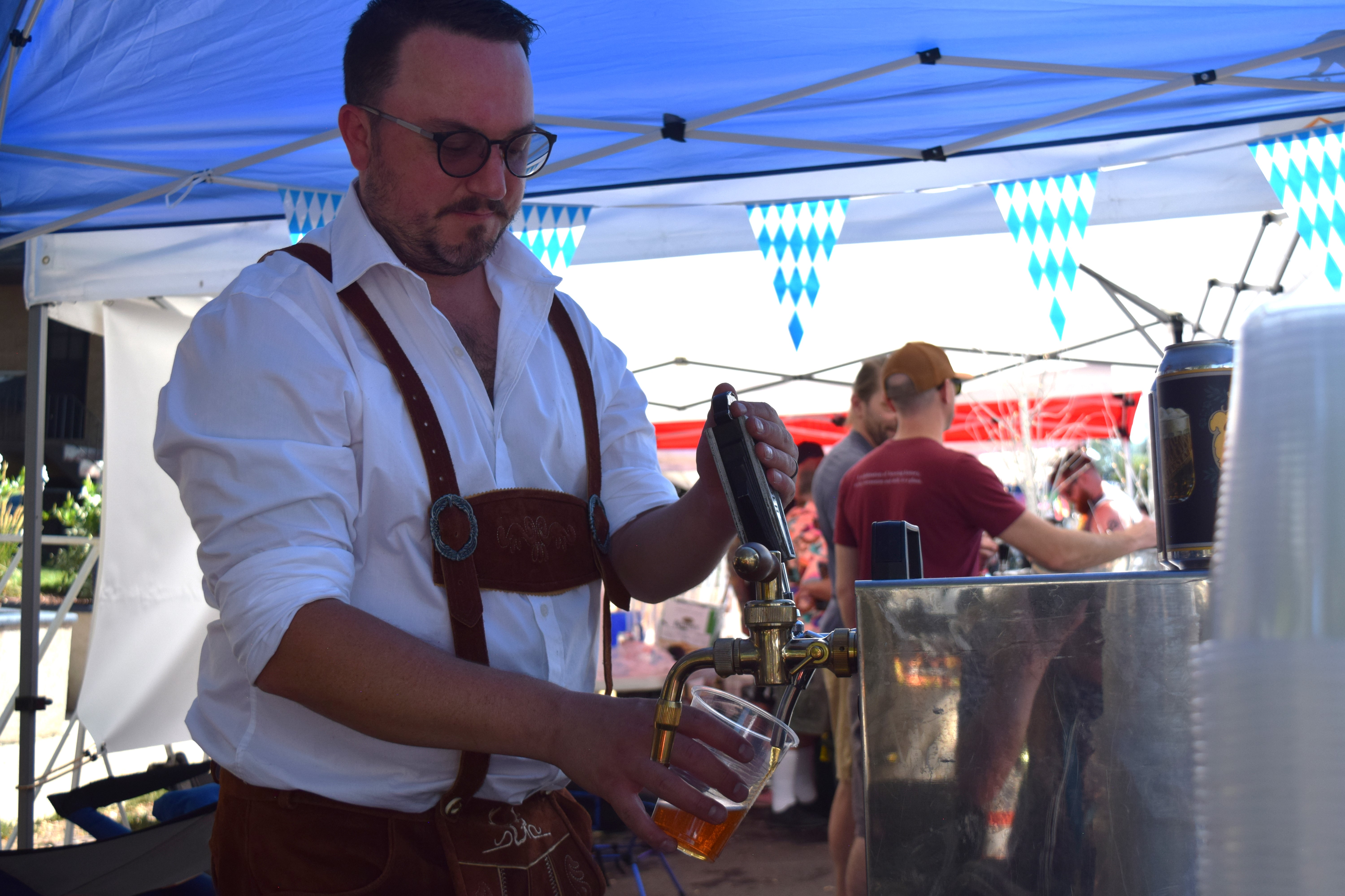 Bryan Schmittel, sales director for Bierstadt Lagerhaus, pours the brewery's German lager at the Pearl Street Oktoberfest on Saturday. 