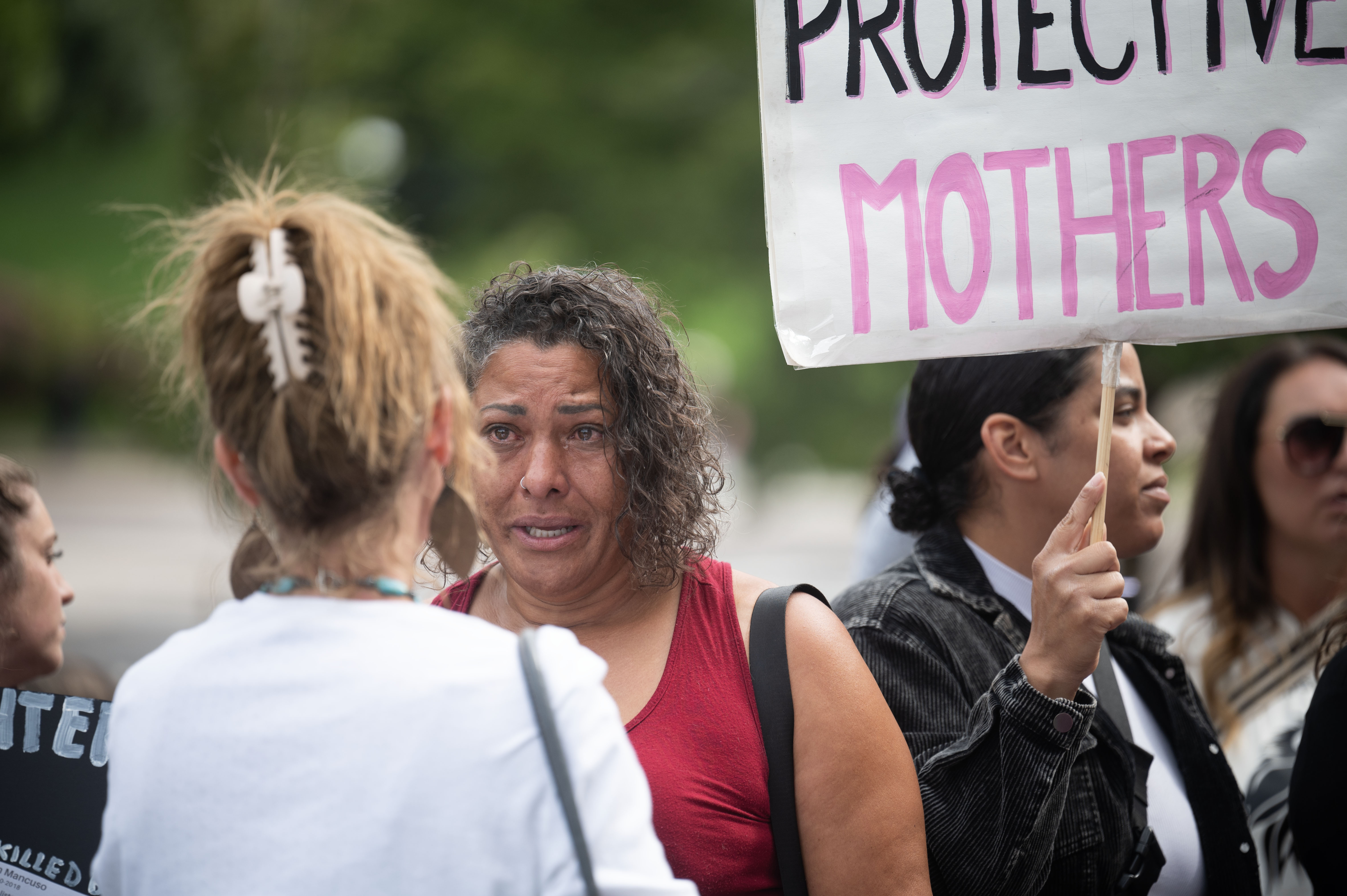Jenna Burnett, an adult survivor, cries as she talks with Rachel Pickrel-Hawkins during a rally calling for family court reforms outside the Ralph L. Carr Colorado Justice Center in Denver on Thursday, Sept. 5, 2024. (Stephen Swofford, Denver Gazette) (Stephen Swofford Denver Gazette)