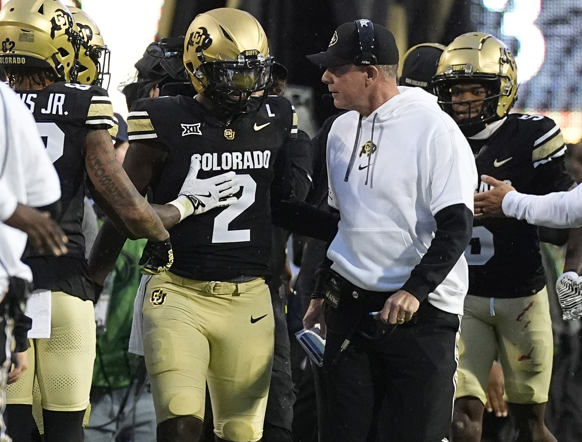 Colorado quarterback Shedeur Sanders (2) confers with offensive coordinator Pat Shurmur, center right, after running for a touchdown in the first half of an NCAA college football game against Baylor, Saturday, Sept. 21, 2024, in Boulder, Colo. (AP Photo/David Zalubowski) (David Zalubowski)