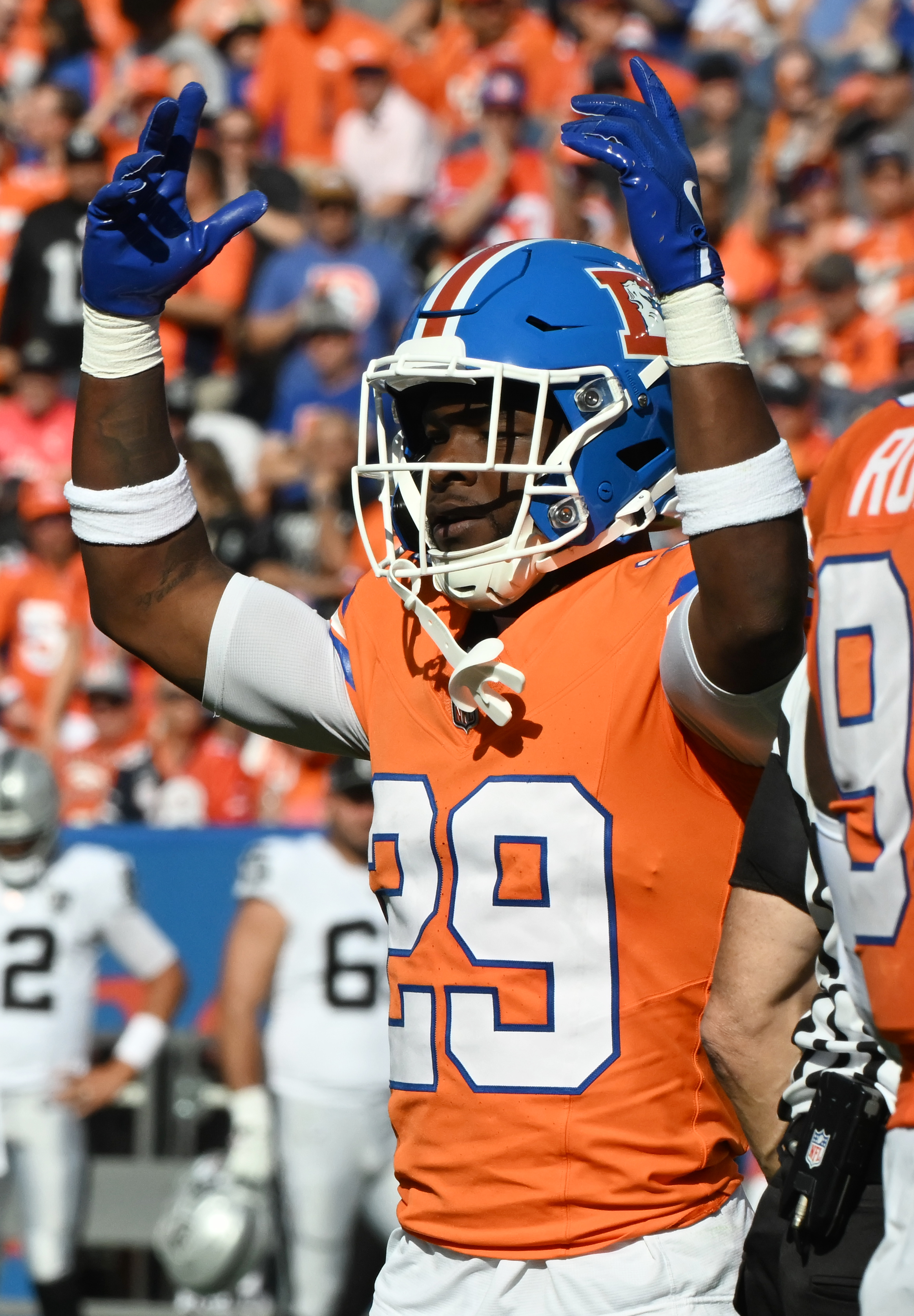 Denver Broncos cornerback Ja'Quan McMillian (29) pumps up the crowd during a game against the Raiders at Empower Field at Mile High on Sunday, Oct. 6, 2024.