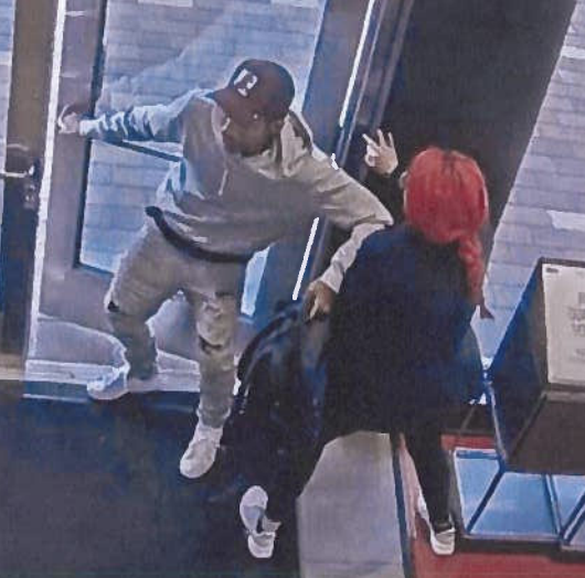 This is a screenshot from surveillance video inside The Sunglass Hut at Southland Mall taken from the suspect's arrest affidavit. It shows a man in a maroon hat and jeans shoving a clerk aside at the front door of the store. (Courtesy Aurora Police department)