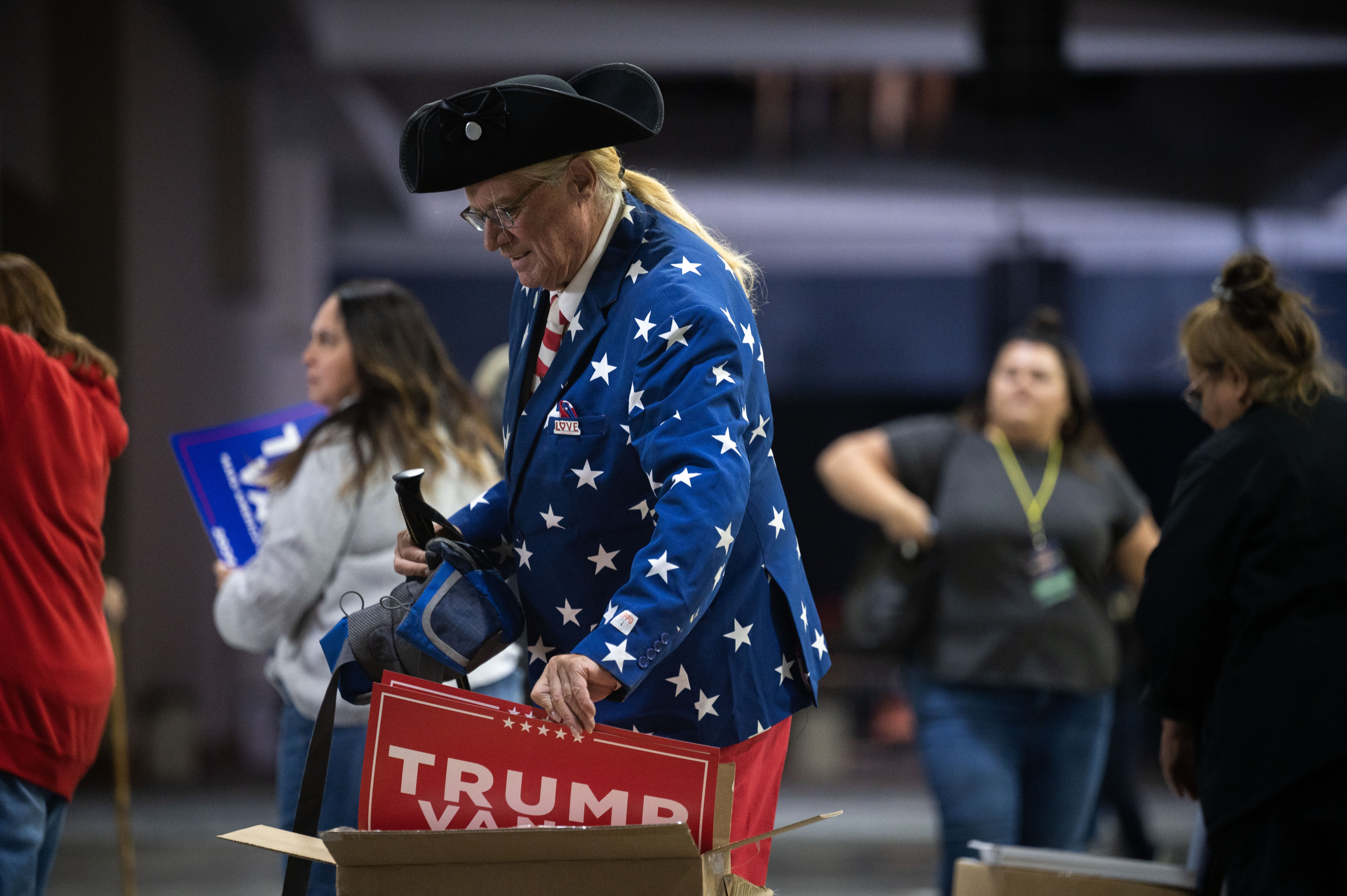 Kurt Albert, from Berthoud, takes a sign on his way into the Gaylord Rockies Resort and Convention Center in Aurora before the start of a trump rally on Friday, Oct. 11, 2024. (Stephen Swofford, Denver Gazette) (Stephen Swofford, Denver Gazette)