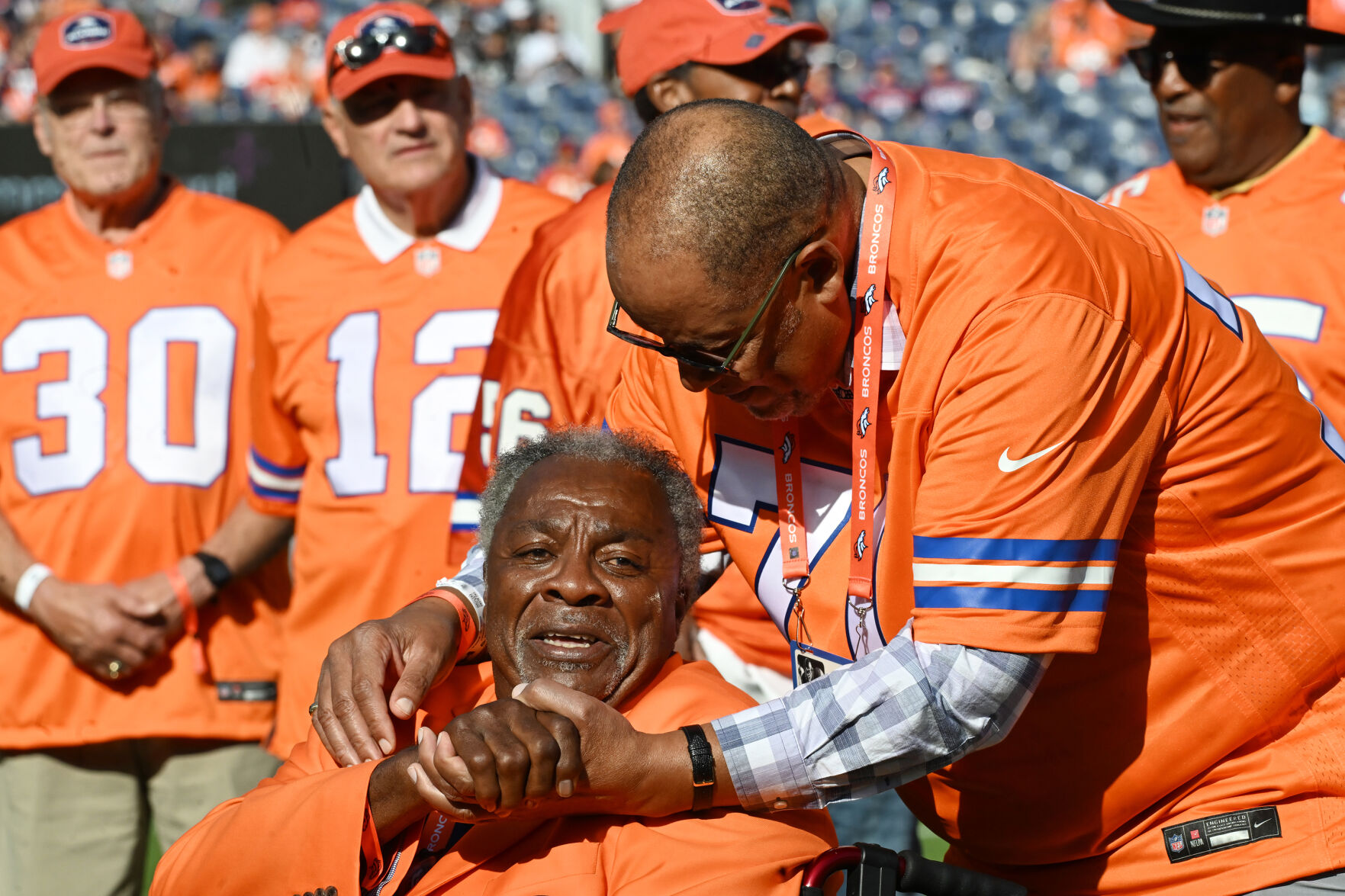 Legendary Bronco Riley Odoms gets a hug from teammate Claudie Minor before a Ring of Fame ceremony. Many members of the ’77 Broncos team, the first Broncos team to go to the Super Bowl, were on hand to see two of their own to be added to the Broncos Ring of Fame. One of the names added was Riley Odoms (foreground) and the other was Steve Foley at Empower Field at Mile High on Sunday, Oct. 6, 2024. (Jerilee Bennett, The Gazette)