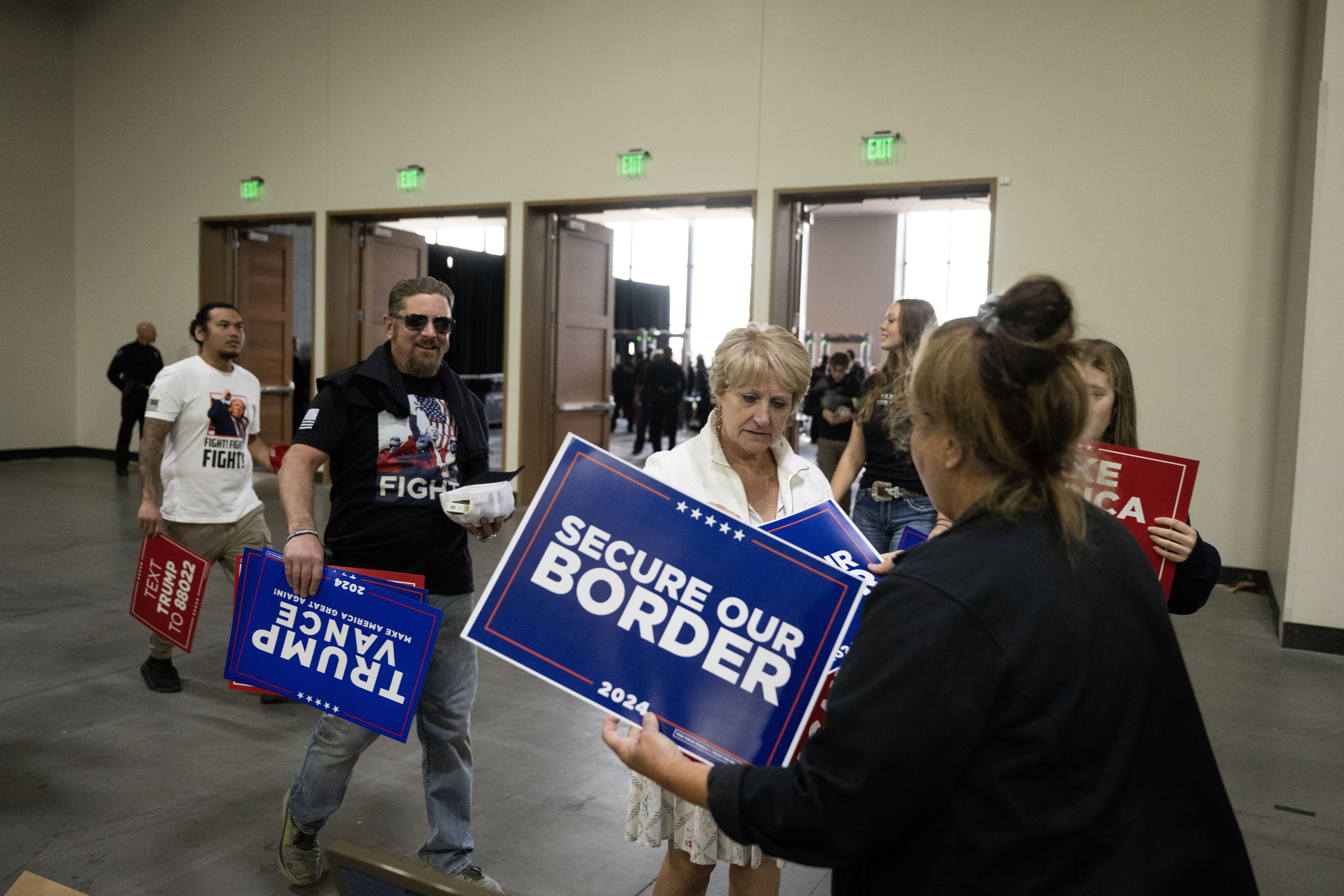 People pick signs to hold on their way into the Gaylord Rockies Resort and Convention Center in Aurora before the start of a Trump rally on Friday, Oct. 11, 2024. (Stephen Swofford, Denver Gazette) (Stephen Swofford, Denver Gazette)