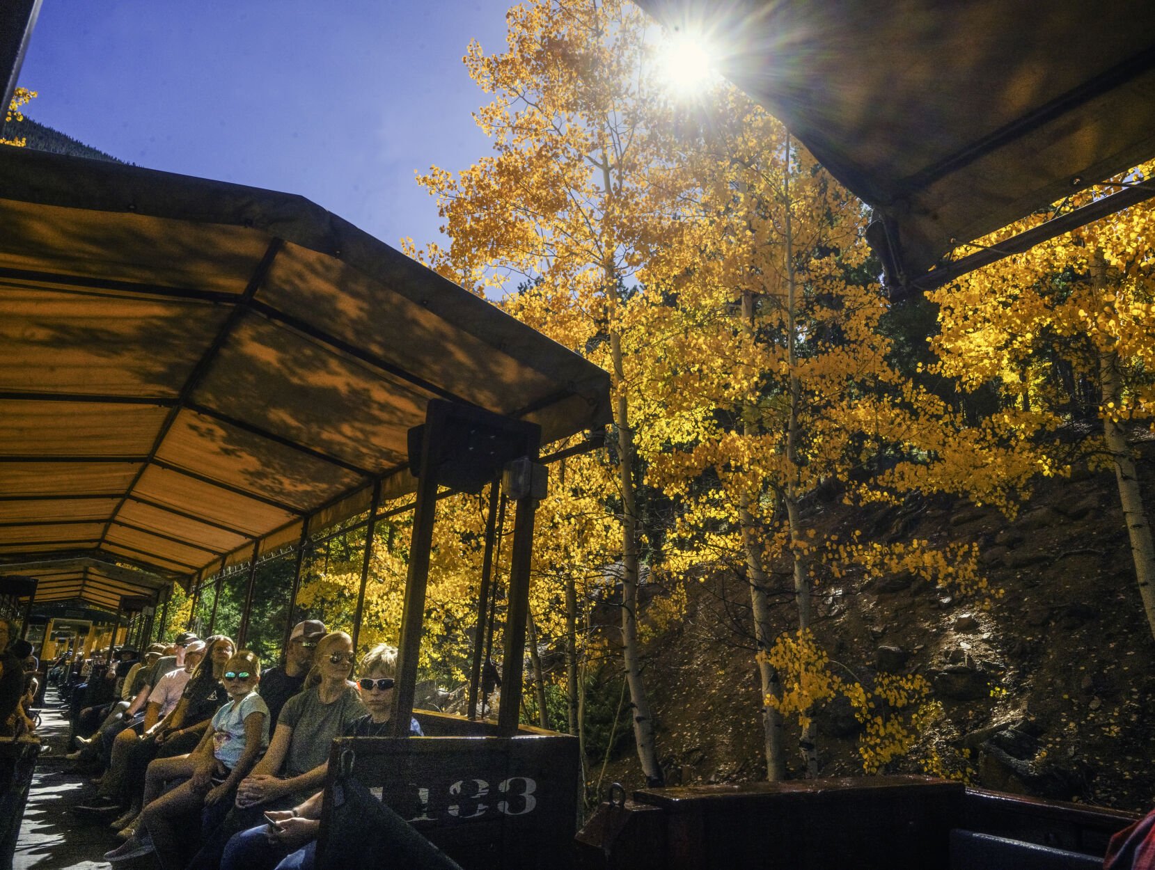 Tourists pass close by the golden aspens while riding in the open-air train on the Georgetown Loop Railroad last month. The tourist train travels between Georgetown and Silver Plume, both old mining towns. (Jerilee Bennett, The Gazette)