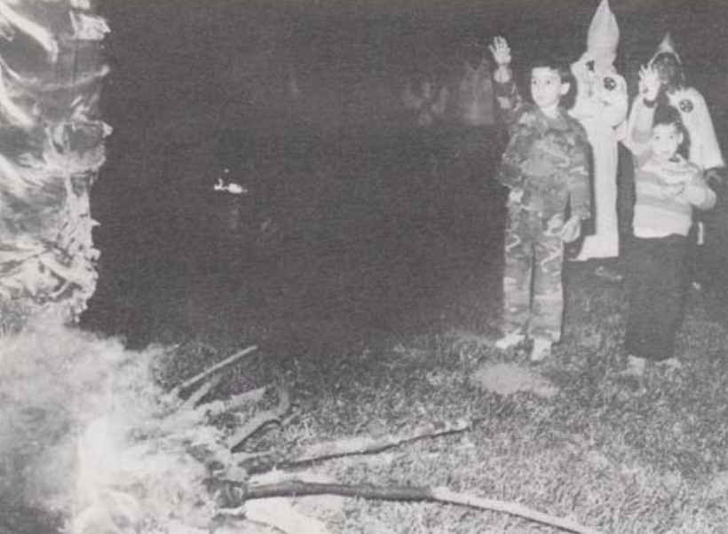 Children salute a burning cross at the 1986 Aryan World Congress held at Pastor Richard Butler's compound in northern Idaho. (ASSOCIATED PRESS/WIDE WORLD PHOTOS)