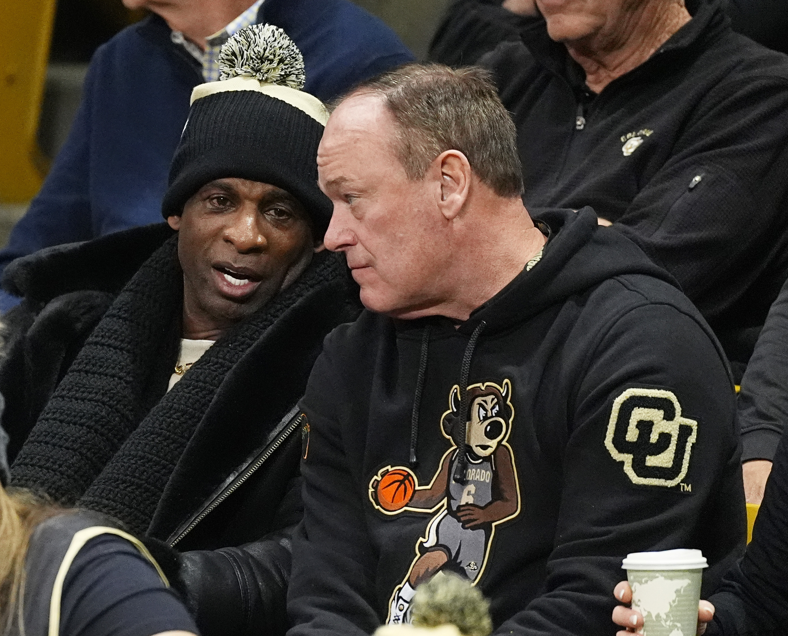 Colorado football coach Deion Sanders, left, chats with athletic director Rick George duirng the first half of an NCAA college basketball game between Colorado and Southern California on Saturday, Jan. 13, 2024, in Boulder, Colo. (AP Photo/David Zalubowski) (David Zalubowski)