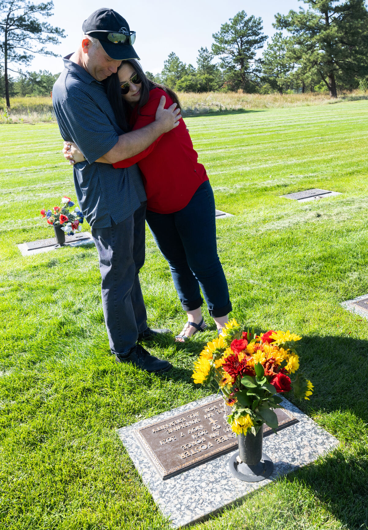 Retired Air Force Lt. Col. Gary Foster and his wife, Colleen, hug after placing fresh flowers at the gravesite of their daughter, Cailin Foster, Friday, Sept. 6, 2024, at the cemetery on the U.S. Air Force Academy. (The Gazette, Christian Murdock) (Christian Murdock, The Gazette)