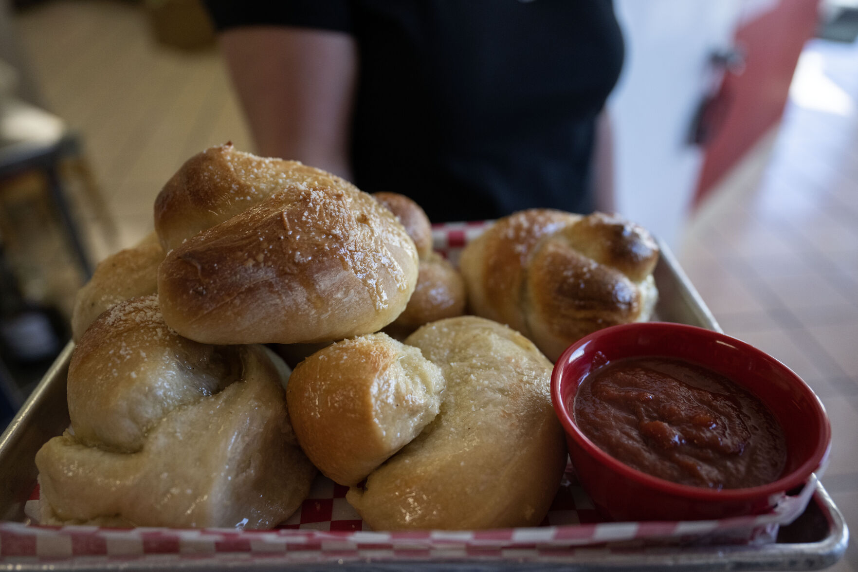 Kylie Corder carries a plate of Garlic Knots to a customer’s table at Grammy’s Goodies in Wheat Ridge on Thursday, Oct. 3. (StephenSwoffordPhotographerstephen.swofford@gazette.comhttps://secure.gravatar.com/avatar/1ddcaf11c5d70eaa58546ddc4e038687?d=mm&r=g)