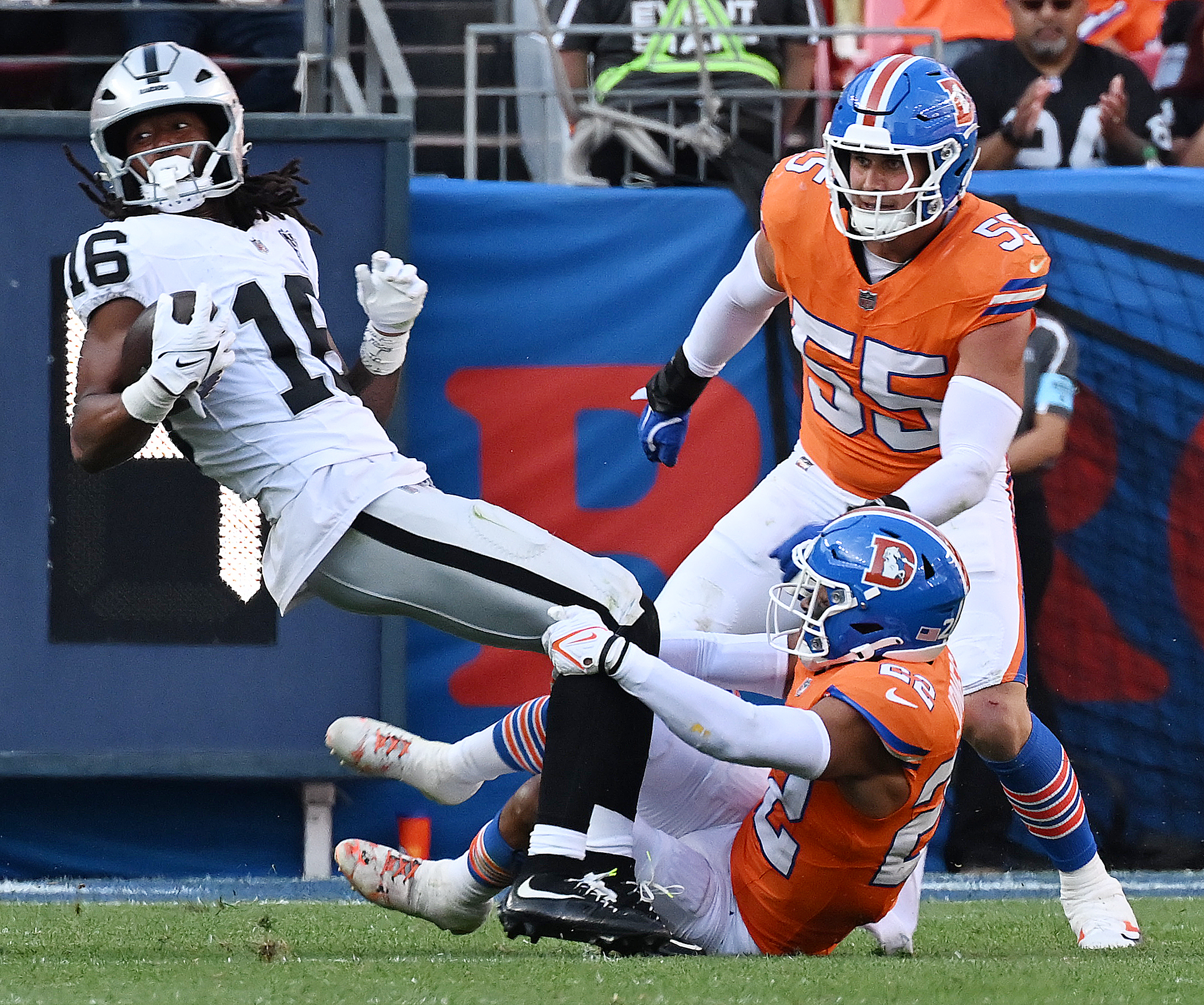 Broncos safety Brandon Jones brings down Las Vegas Raiders wide receiver Jakobi Meyers as Denver Broncos linebacker Cody Barton (55) backs him up  against the Raiders at Empower Field at Mile High on Oct. 6. (Jerilee Bennett, The Gazette)