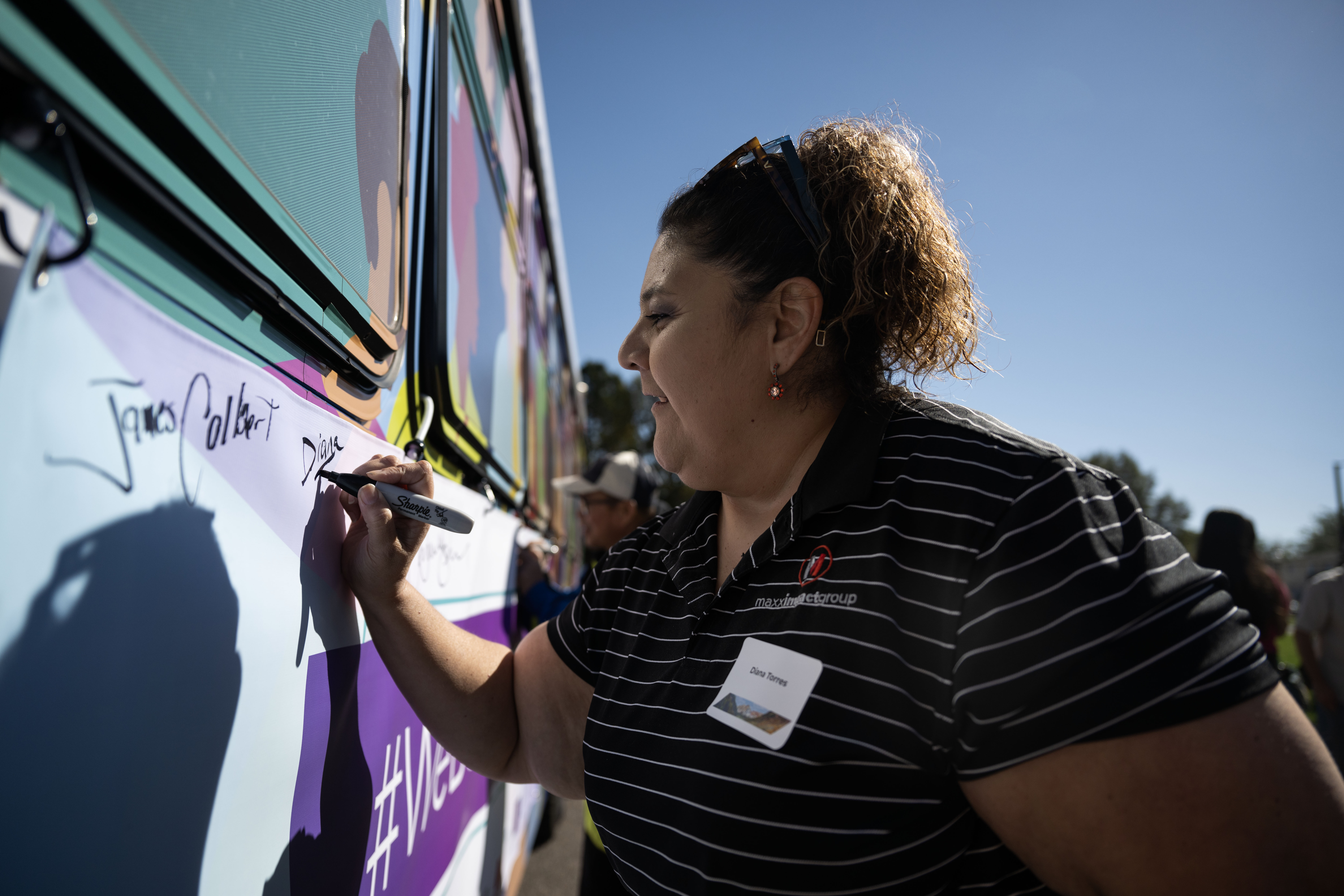 Diana Torres signs a banner on the side of a bus during the groundbreaking ceremony on Friday, Oct. 4, 2024 for a $280 million project that will introduce Denver’s first bus rapid transit aimed at transforming how bus service operates on East Colfax Avenue. (Stephen Swofford, Denver Gazette) (StephenSwoffordPhotographerstephen.swofford@gazette.comhttps://secure.gravatar.com/avatar/1ddcaf11c5d70eaa58546ddc4e038687?d=mm&r=g)