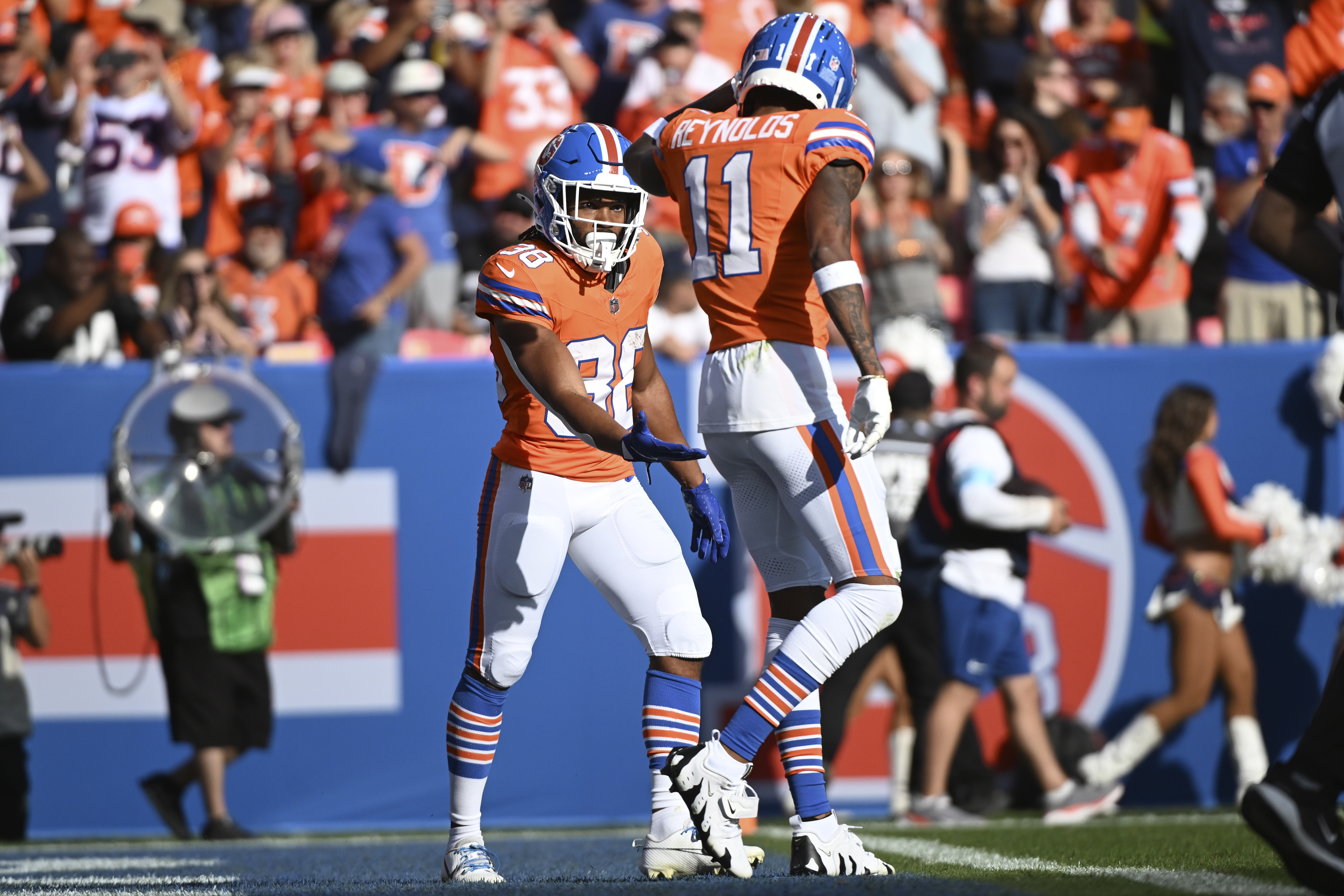Denver Broncos running back Jaleel McLaughlin (38) is greeted by teammate wide receiver Josh Reynolds (11) after a 4-yard reception for a touchdown during the second half of an NFL football game against the Las Vegas Raiders, Sunday, Oct. 6, 2024, in Denver. (AP Photo/Geneva Heffernan) (Geneva Heffernan)