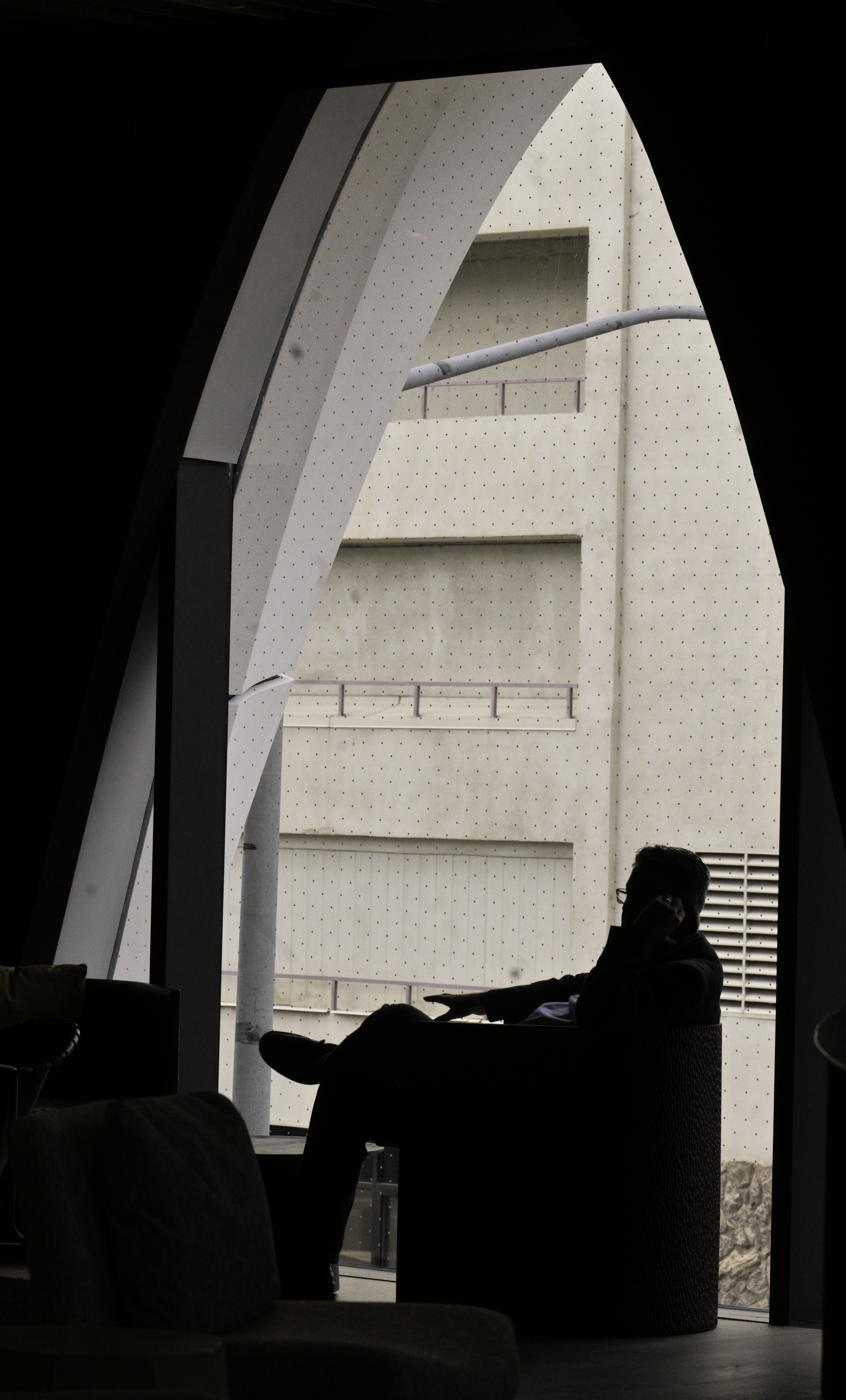 A man is silhouetted in one of the eye shaped windows of the Populus Hotel. The windows are designed to be like the 