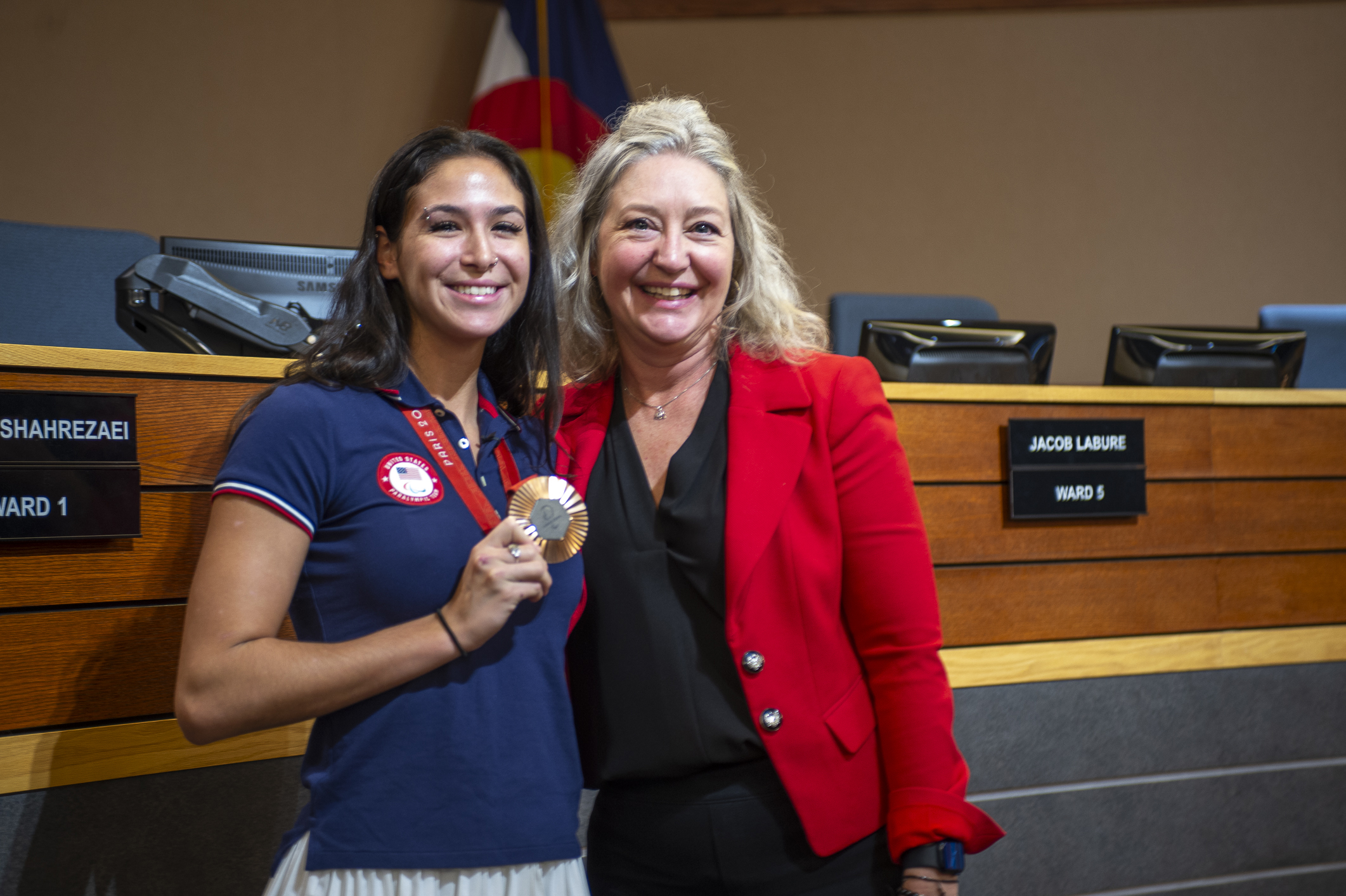 Paralympic bronze medalist Beatriz Hatz shows off her medal from the 2024 Paralympic Summer Games in Paris while posing with Lakewood Mayor Wendi Strom in Council Chambers on Monday, Oct. 28, 2024. (DeborahSmithGeneral Assignment Reporterdeborah.smith@denvergazette.comhttps://denvergazette.com/content/tncms/avatars/5/cb/928/5cb9281a-1916-11ef-a934-ff8eced4f17d.8e406ef28428e7c4f743743e38d7aa35.png)