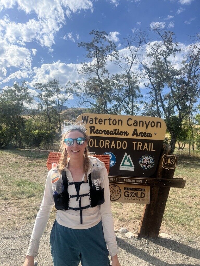 Meredith Hughes dons a tiara at the sign marking the northernmost terminus of the Colorado Trail. (Courtesy of Meredith Hughes)