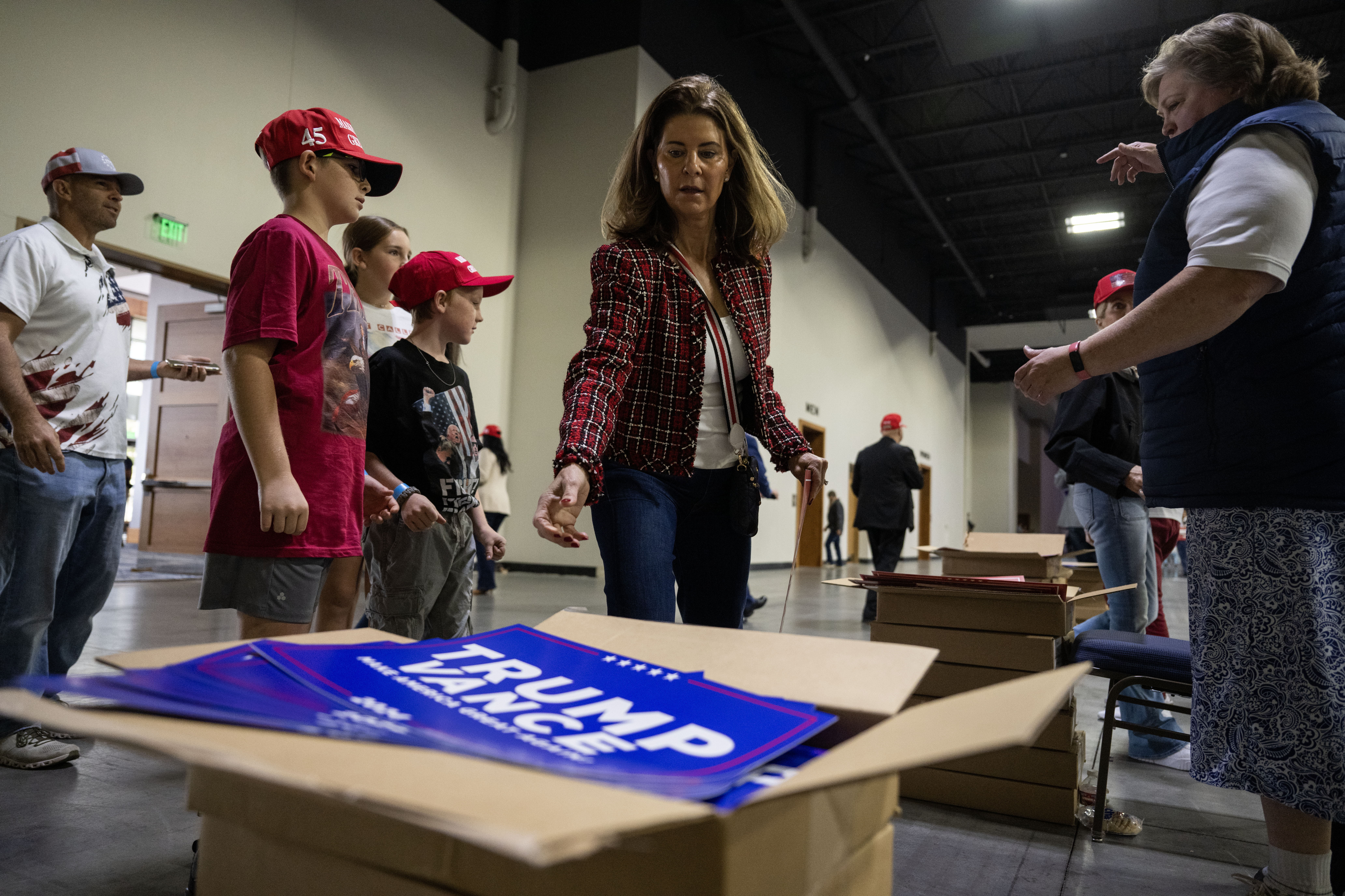 People pick signs to hold on their way into the Gaylord Rockies Resort and Convention Center in Aurora before the start of a Trump rally on Friday, Oct. 11, 2024. (Stephen Swofford, Denver Gazette) (Stephen Swofford Denver Gazette)