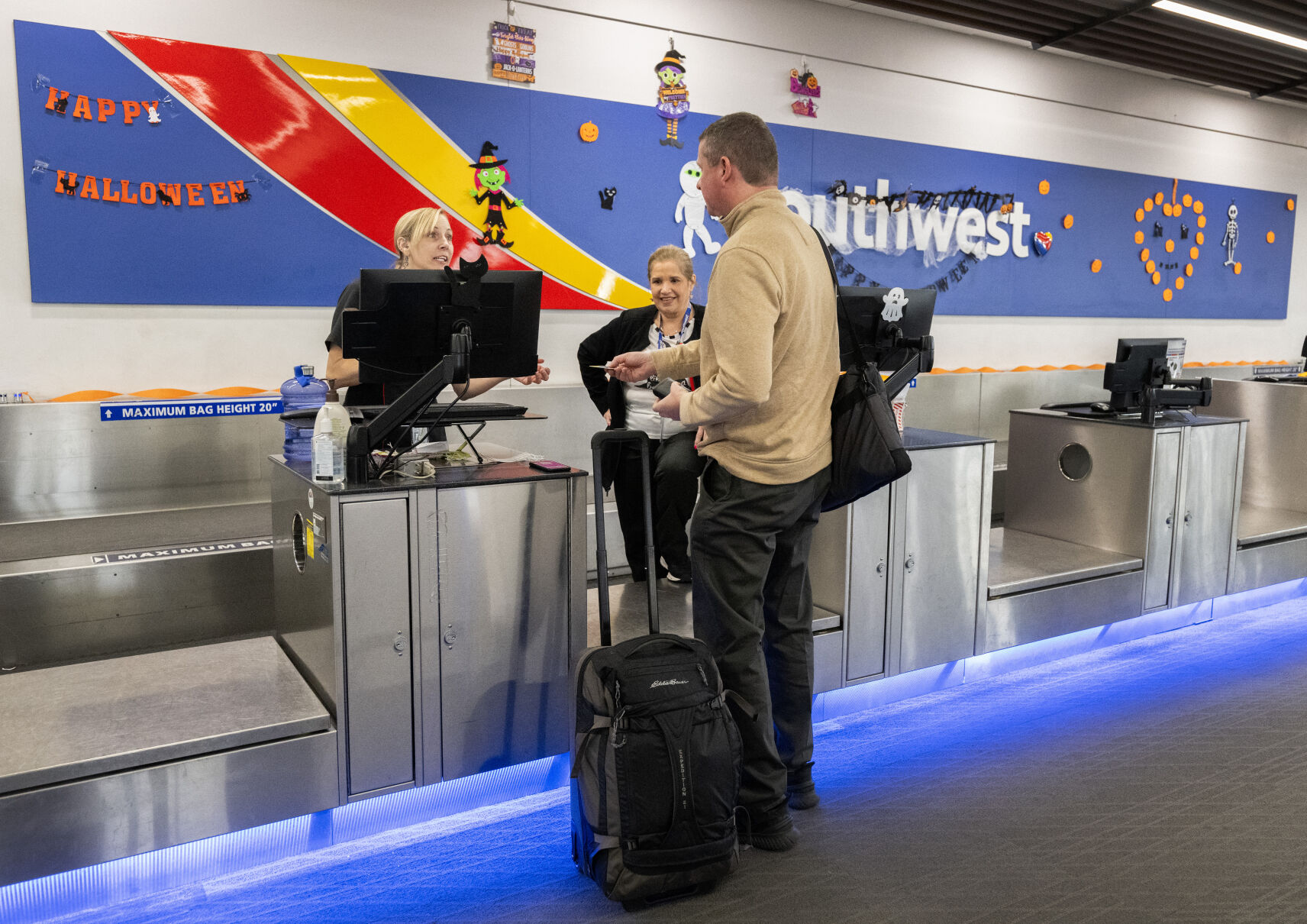 Customer service agents Kat Scott, left, and LisaMarie Andrews help a traveler check in at the Southwest Airlines counter Wednesday, Oct. 30, 2024, at the Colorado Springs Airport. Southwest Airlines announced a non-stop flight to Cancun, Mexico, from Colorado Springs that will begin in June of 2025. It'll be the first international flight out of the Colorado Springs Airport. (The Gazette, Christian Murdock) (Christian Murdock)