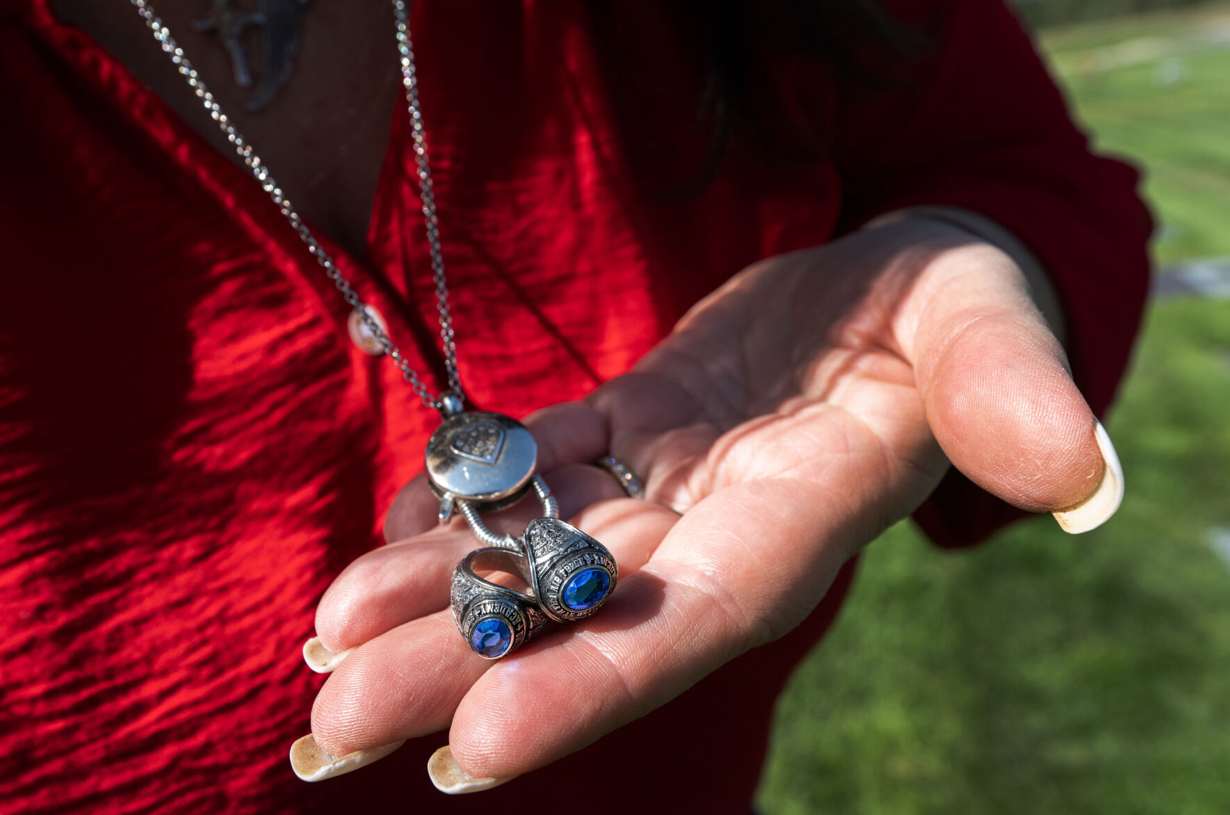 Colleen Foster holds the class rings of both her daughters who graduated from the U.S. Air Force Academy Friday, Sept. 6, 2024, while attending the gravesite of her oldest daughter, Cailin, who died of suicide on Nov. 7, 2021, a few months into her first assignment at the Air Force Research Lab at Wright-Patterson Air Force Base in Ohio. (The Gazette, Christian Murdock) (Christian Murdock, The Gazette)