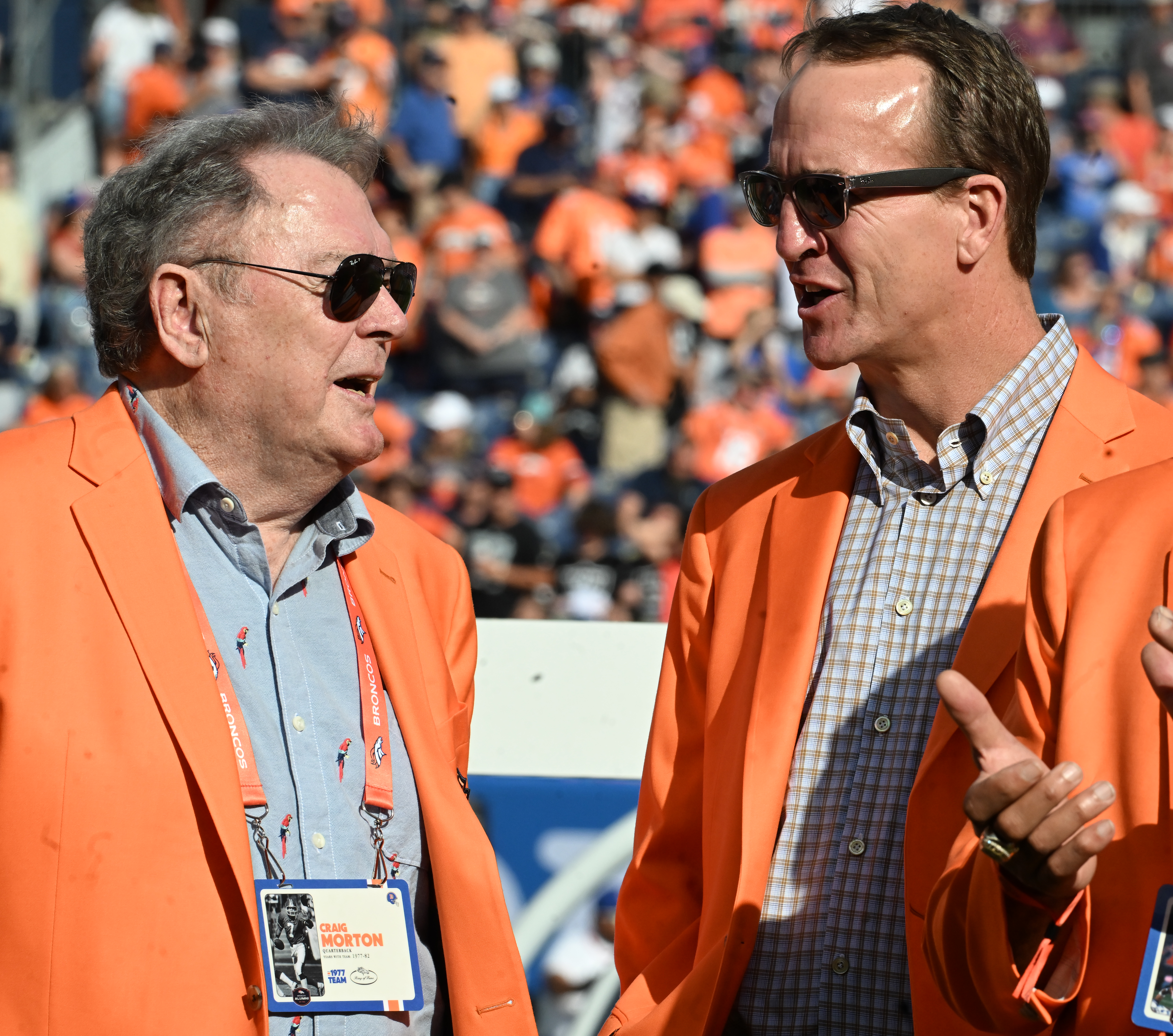 Legendary Broncos quarterbacks Craig Morton and Peyton Manning chat before a ceremony honoring the ’77 Bronco team, the first Broncos team to go to the Super Bowl. The Broncos were playing against the Raiders at Empower Field at Mile High on Sunday, Oct. 6, 2024.