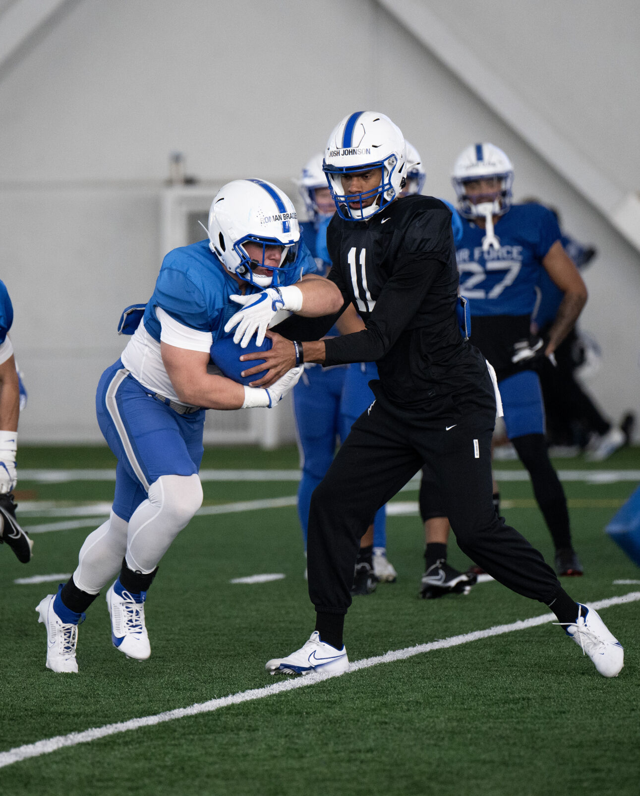 Air Force’s Josh Johnson hands the ball to Roman Bradley during football practice on Saturday, Feb. 24, 2024, at the Holaday Athletic Center at the Air Force Academy. (Parker Seibold, The Gazette) (Parker Seibold)