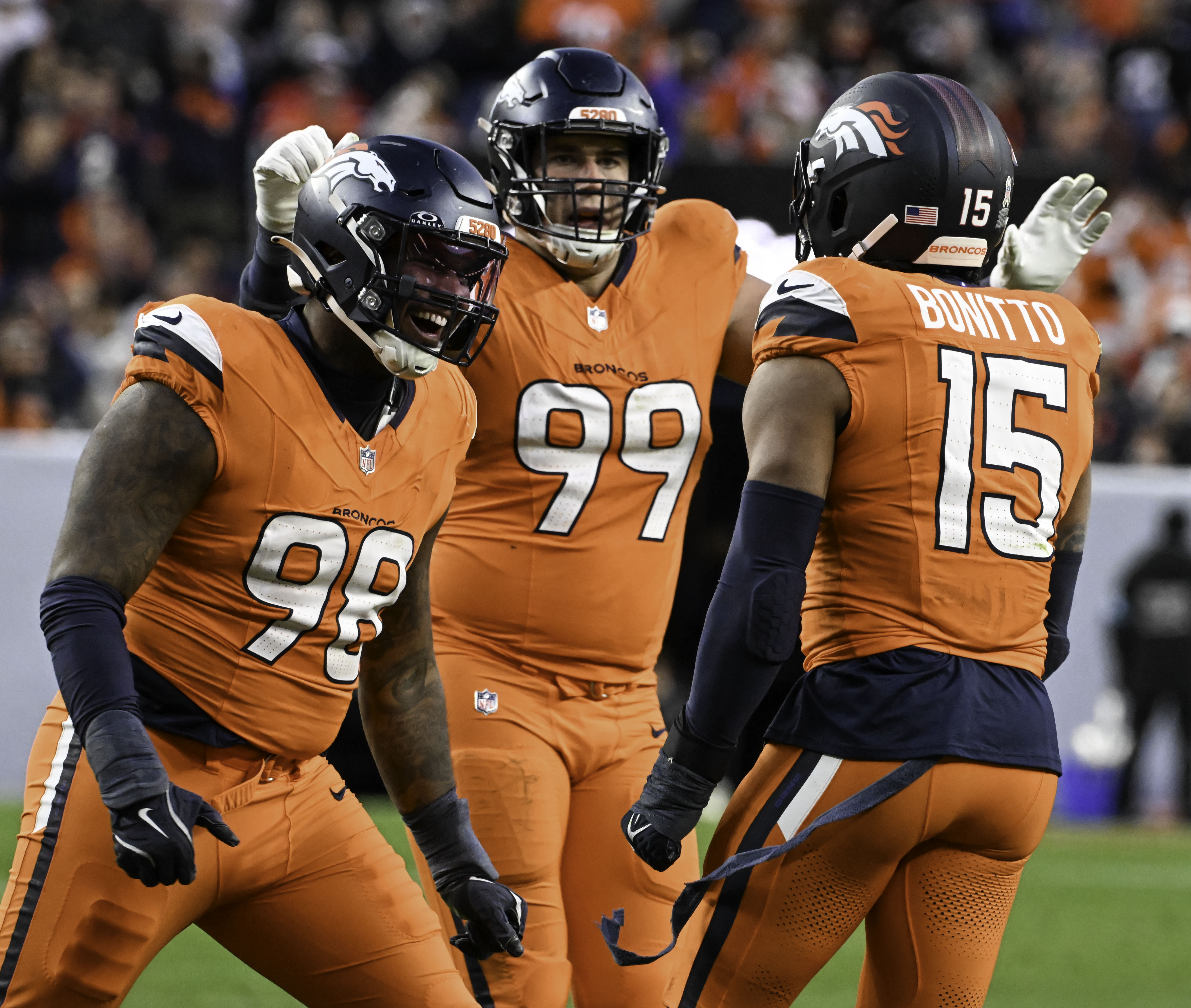 Denver Broncos defensive end John Franklin-Myers (98) and Denver Broncos defensive end Zach Allen (99) celebrate with Denver Broncos linebacker Nik Bonitto (15) after Bonitto got a sack during a game against the Falcons at Empower Field at Mile High on Sunday, Nov. 17, 2024. (Jerilee Bennett,The Gazette)