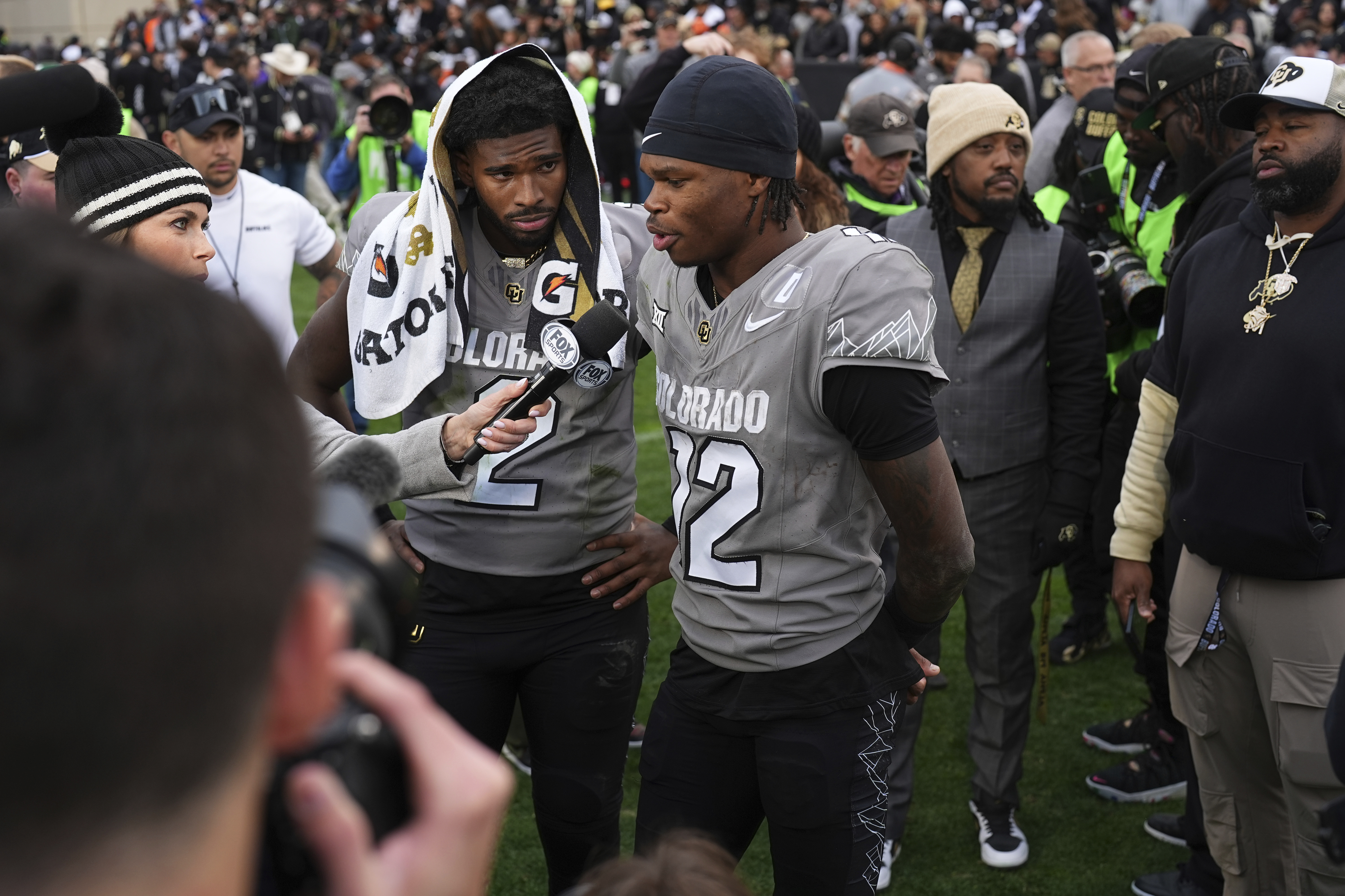 Colorado wide receiver Travis Hunter (12) answers a question during a television interview as Colorado quarterback Shedeur Sanders (2) listens after an NCAA college football game Saturday, Nov. 16, 2024, in Boulder, Colo. (AP Photo/David Zalubowski) (David Zalubowski)