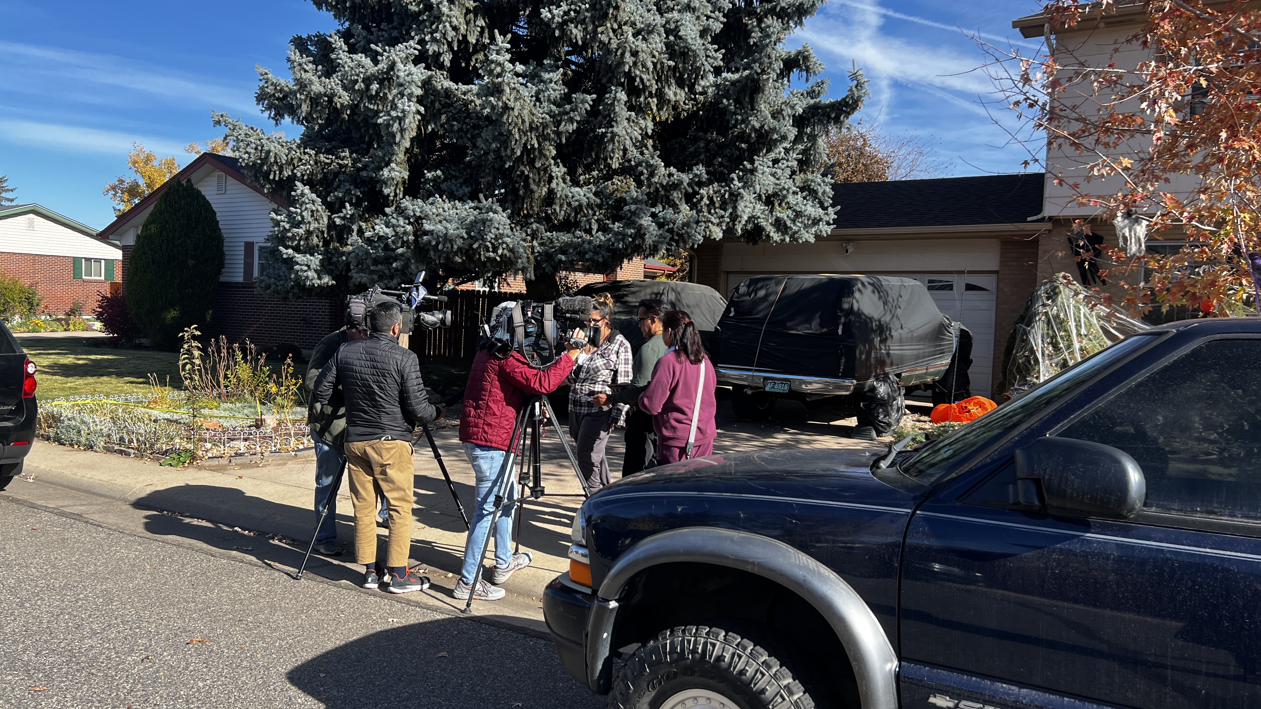 TV crews speak with law enforcement outside of a home in the 200 block of Belford Drive, on Nov. 1, 2024. (Deborah Grigsby, The Denver Gazette)