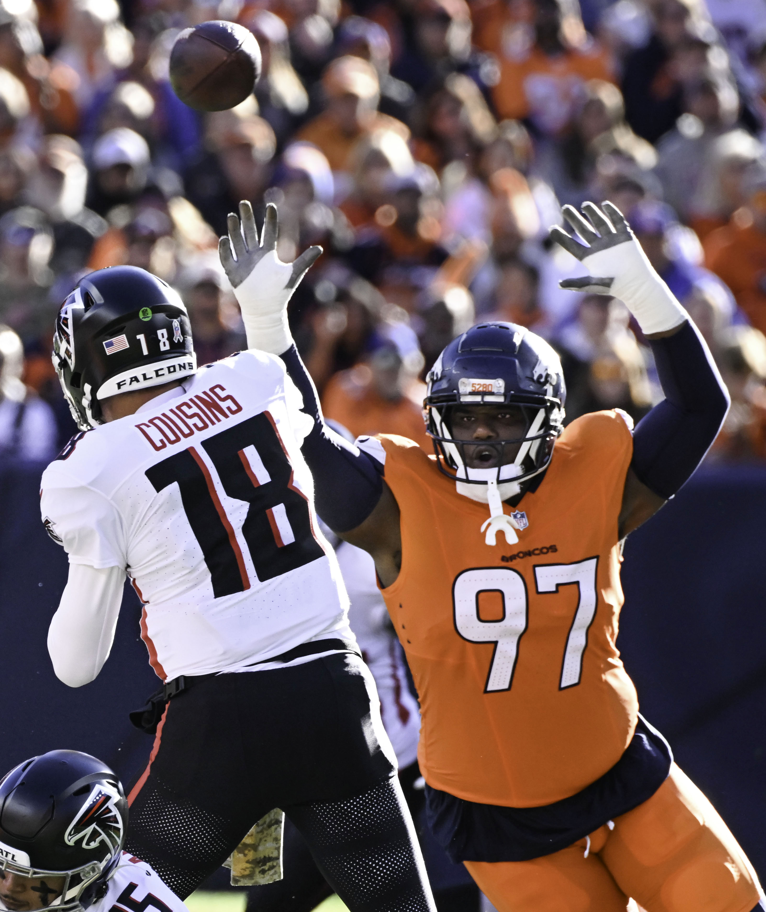 Atlanta Falcons quarterback Kirk Cousins (18) is pressured by Denver Broncos defensive tackle Malcolm Roach (97) during the first quarter of a game at Empower Field at Mile High on Sunday, Nov. 17, 2024. The Broncos defeated the Falcons 38-6. (Jerilee Bennett,The Gazette)