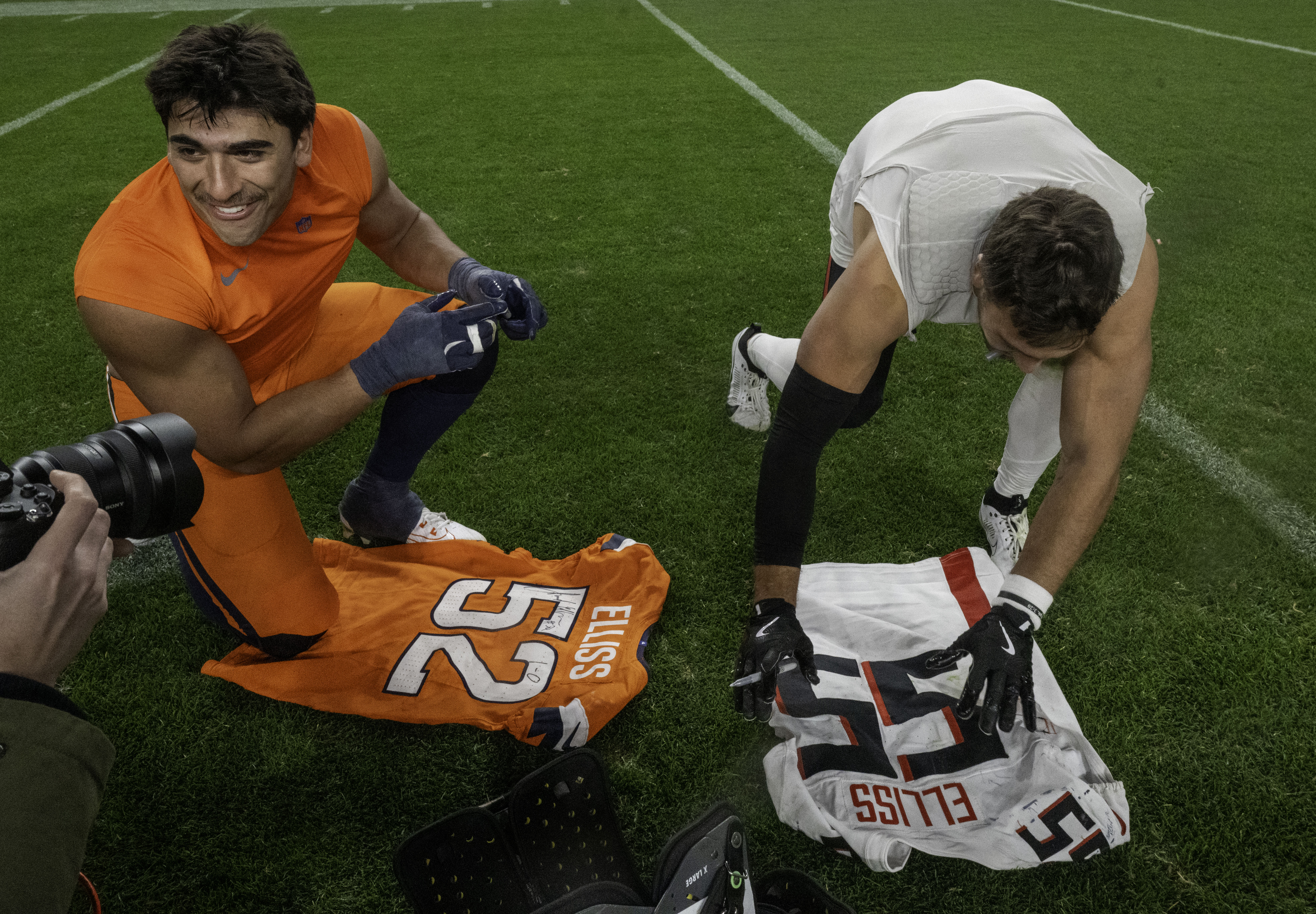 Brothers Denver Broncos linebacker Jonah Elliss (52) and Atlanta Falcons linebacker Kaden Elliss (55)(left to right) trade jerseys after a game at Empower Field at Mile High on Sunday, Nov. 17, 2024.