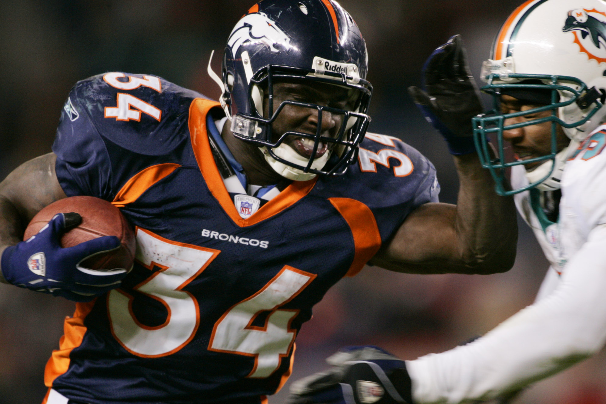 Denver Broncos' Reuben Droughns (34) stiff arms Miami Dolphins' Derrick Pope as Droughns picks up a first down in the fourth quarter in Denver, Sunday, Dec. 12, 2004. (AP Photo/Jack Dempsey) (JACK DEMPSEY)