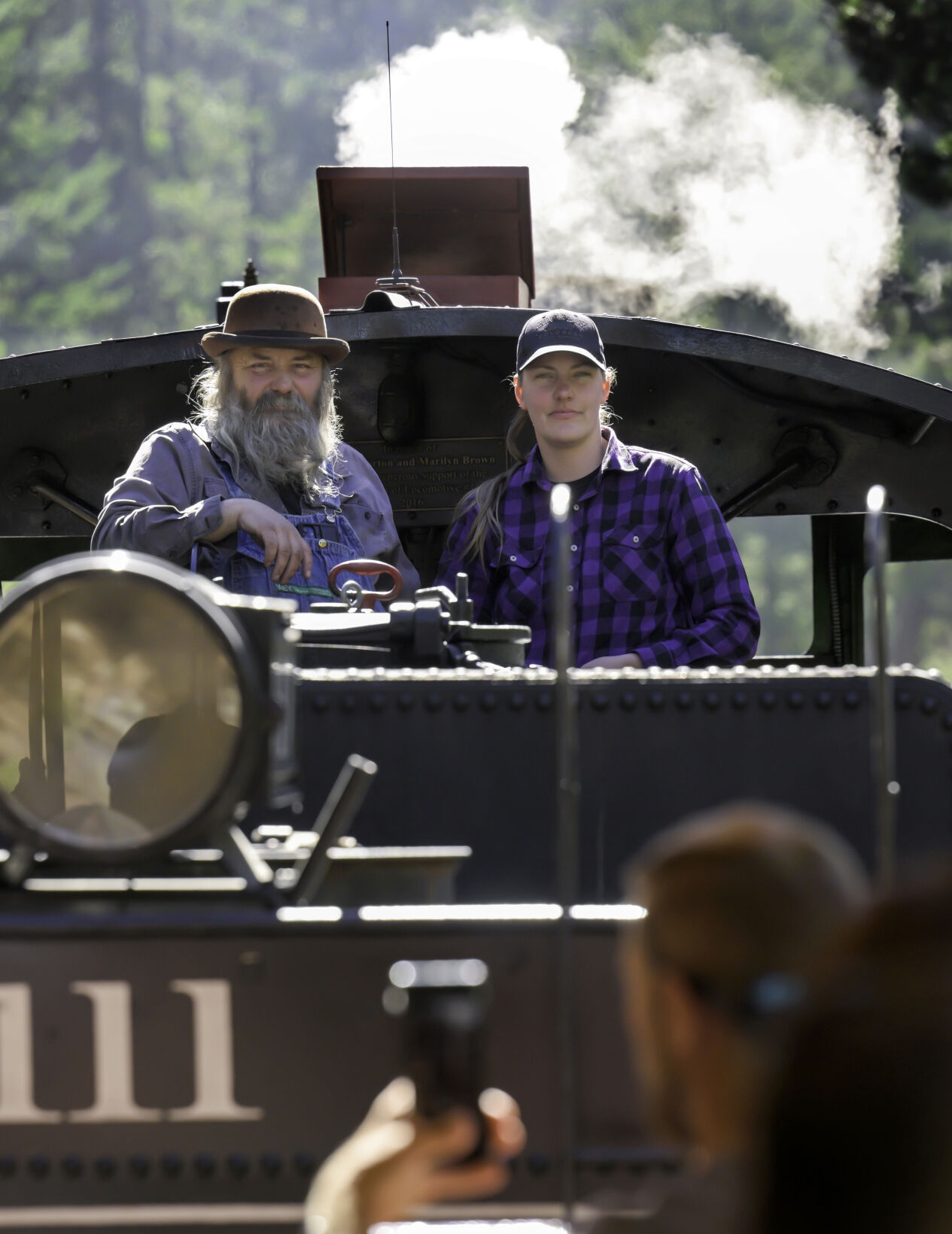 During a stop, female engineer Jenn Jenks and her stepfather Sam McCloskey emerge from the cab to pose for photos for the tourists on Georgetown Loop Railroad on Wednesday, Sept. 25, 2025. (Jerilee Bennett The Gazette)