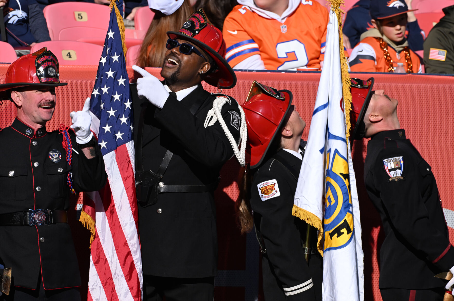 Former Bronco Wesley Duke (second from left) looks up at skydivers coming into the stadium while participating in an honor guard before a game against the Falcons on Sunday, Nov. 17, 2024. Duke is now a member of the Denver Fire Dept. (Jerilee Bennett,The Gazette)