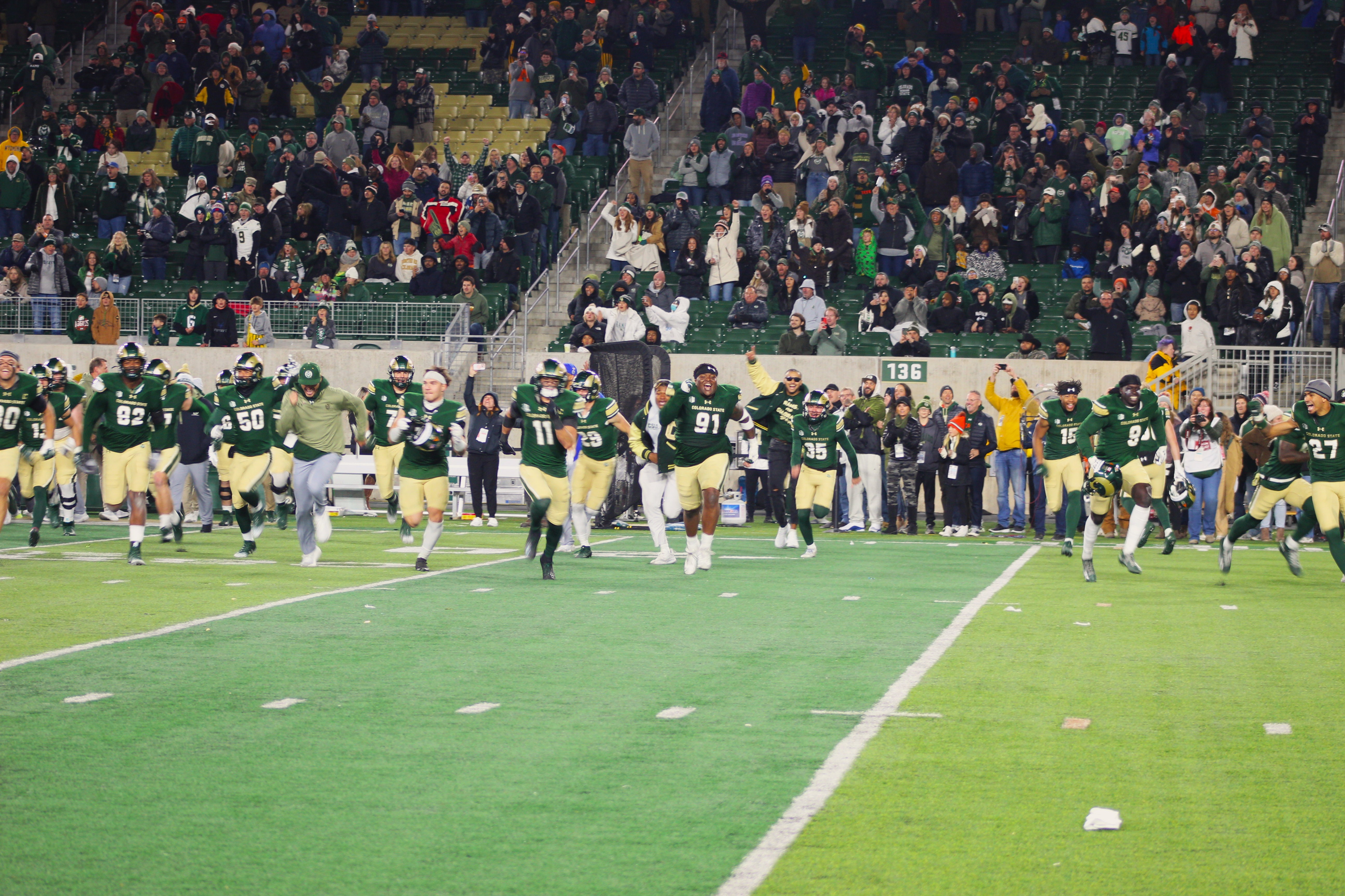 Colorado State players run across the field to grab the Bronze Boot trophy after a Border War rivalry win against Wyoming on Friday, Nov. 11 at Canvas Stadium in Fort Collins. (Tyler King, The Denver Gazette)