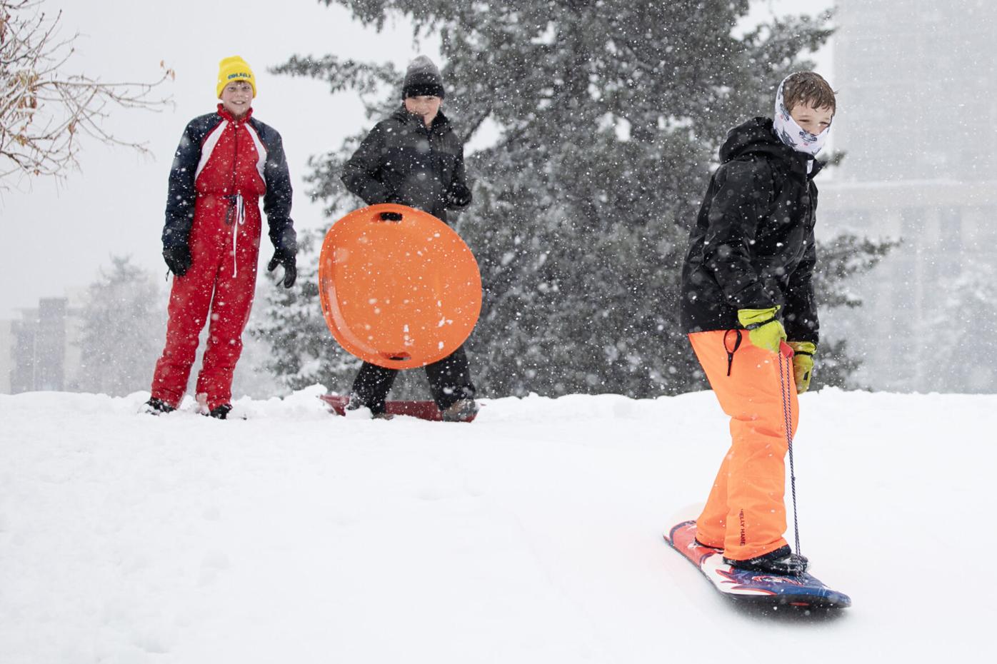 Case Cochran, left, and Grant Roesler, center, watch their friend Franklin Weber snowboard into a jump