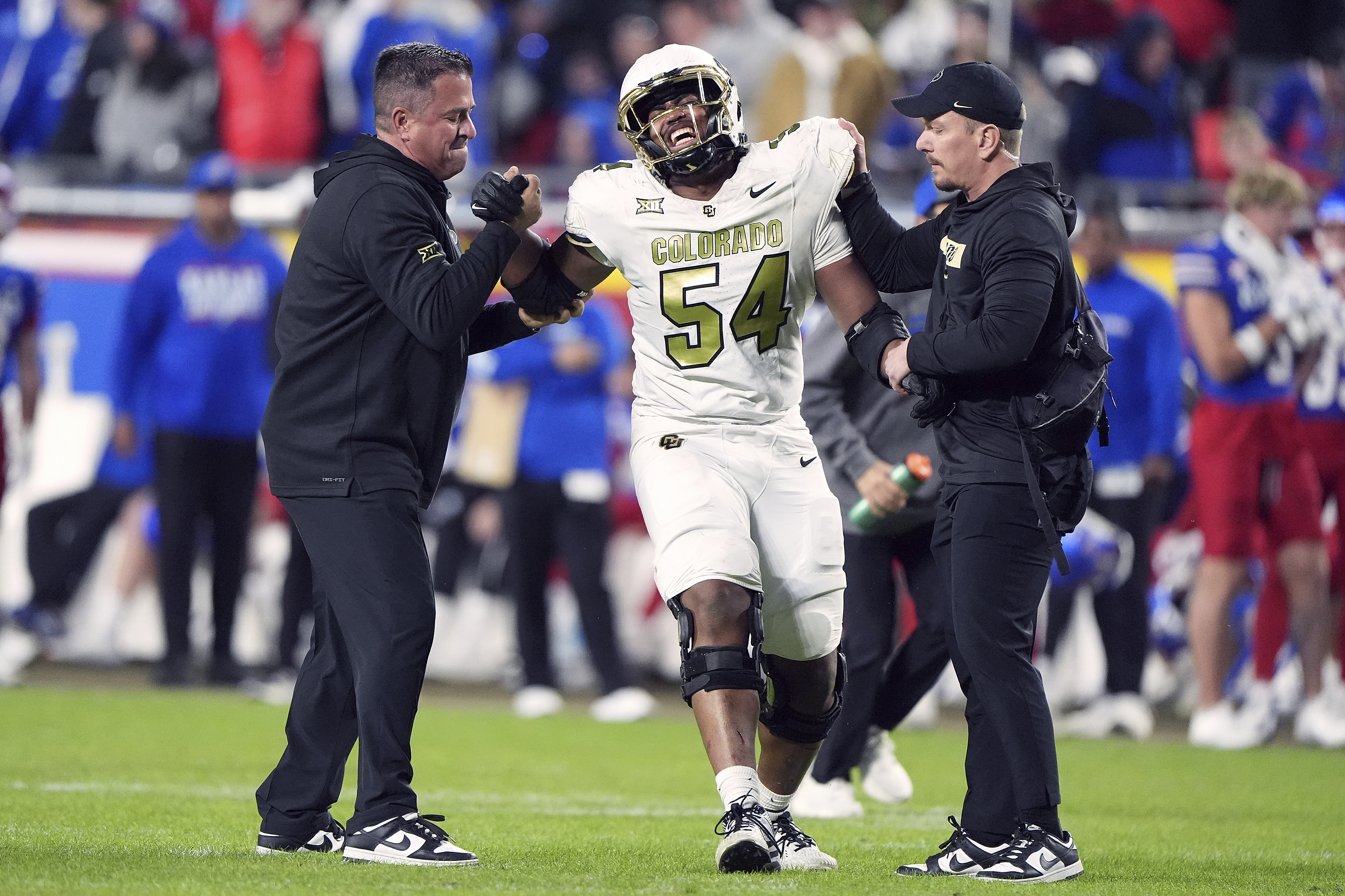 Colorado offensive tackle Phillip Houston (54) is helped off the field after getting injured during the second half of an NCAA college football game against Kansas, Saturday, Nov. 23, 2024, in Kansas City, Mo. (AP Photo/Charlie Riedel) (Charlie Riedel)