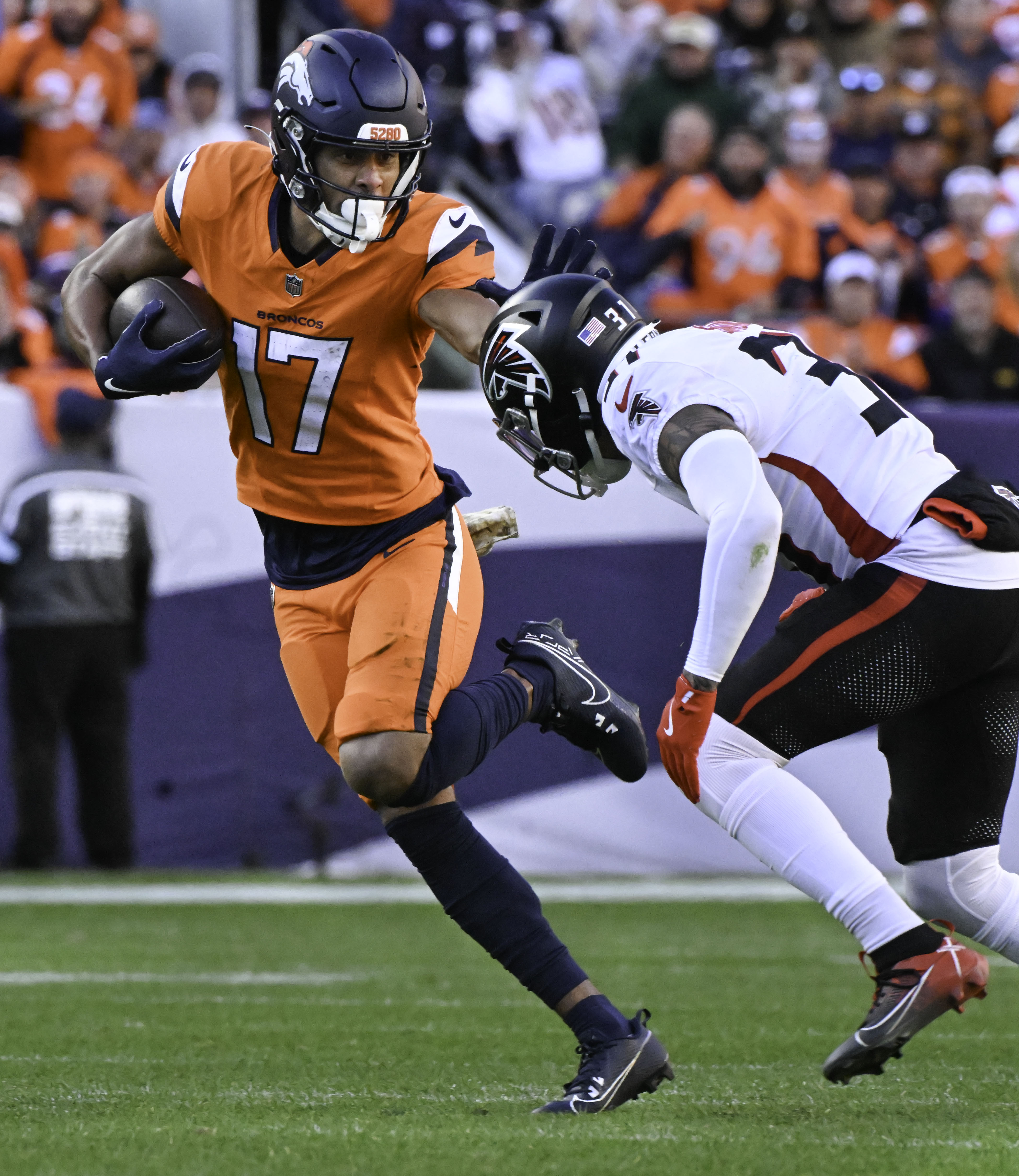 Denver Broncos wide receiver Devaughn Vele (17) stiff arms Atlanta Falcons safety Justin Simmons (31) during the second quarter of a game at Empower Field at Mile High on Sunday, Nov. 17, 2024. The Broncos defeated the Falcons 38-6. (Jerilee Bennett,The Gazette)