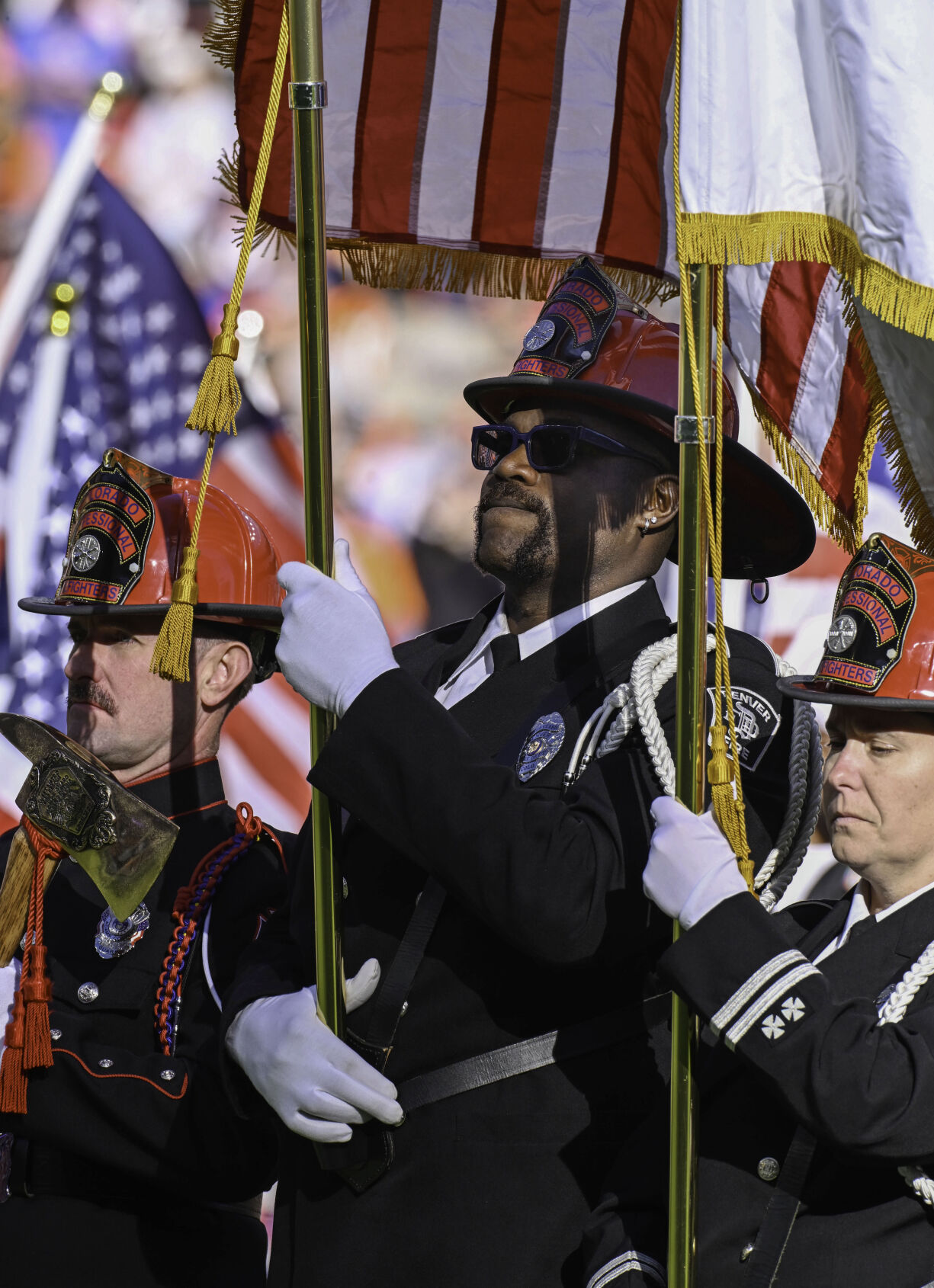 Former Bronco Wesley Duke (middle) holds the U.S. flag while participating in an honor guard before a game against the Falcons on Sunday, Nov. 17, 2024. Duke is now a member of the Denver Fire Dept. (Jerilee Bennett,The Gazette)
