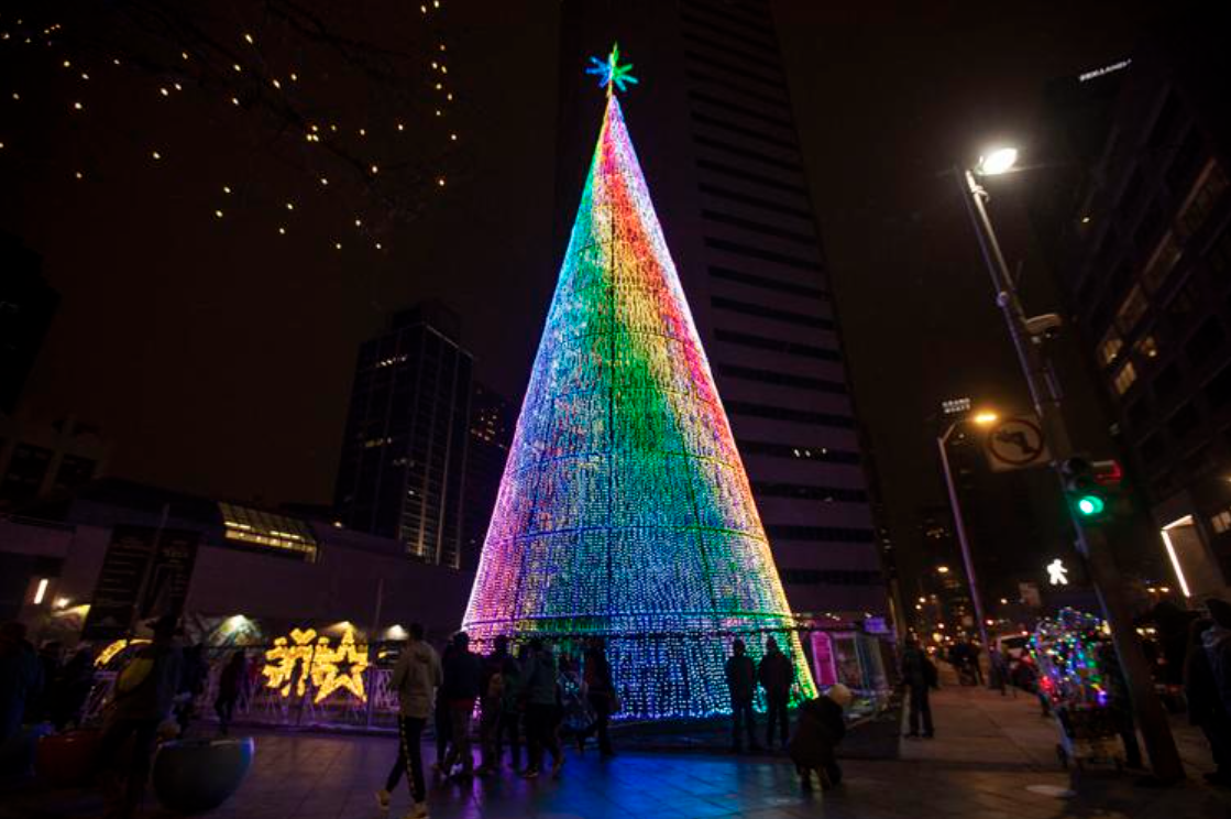 People view the Mile High Tree, a 110-foot-tall art installation in Denver. (Chancey Bush/ The Gazette)