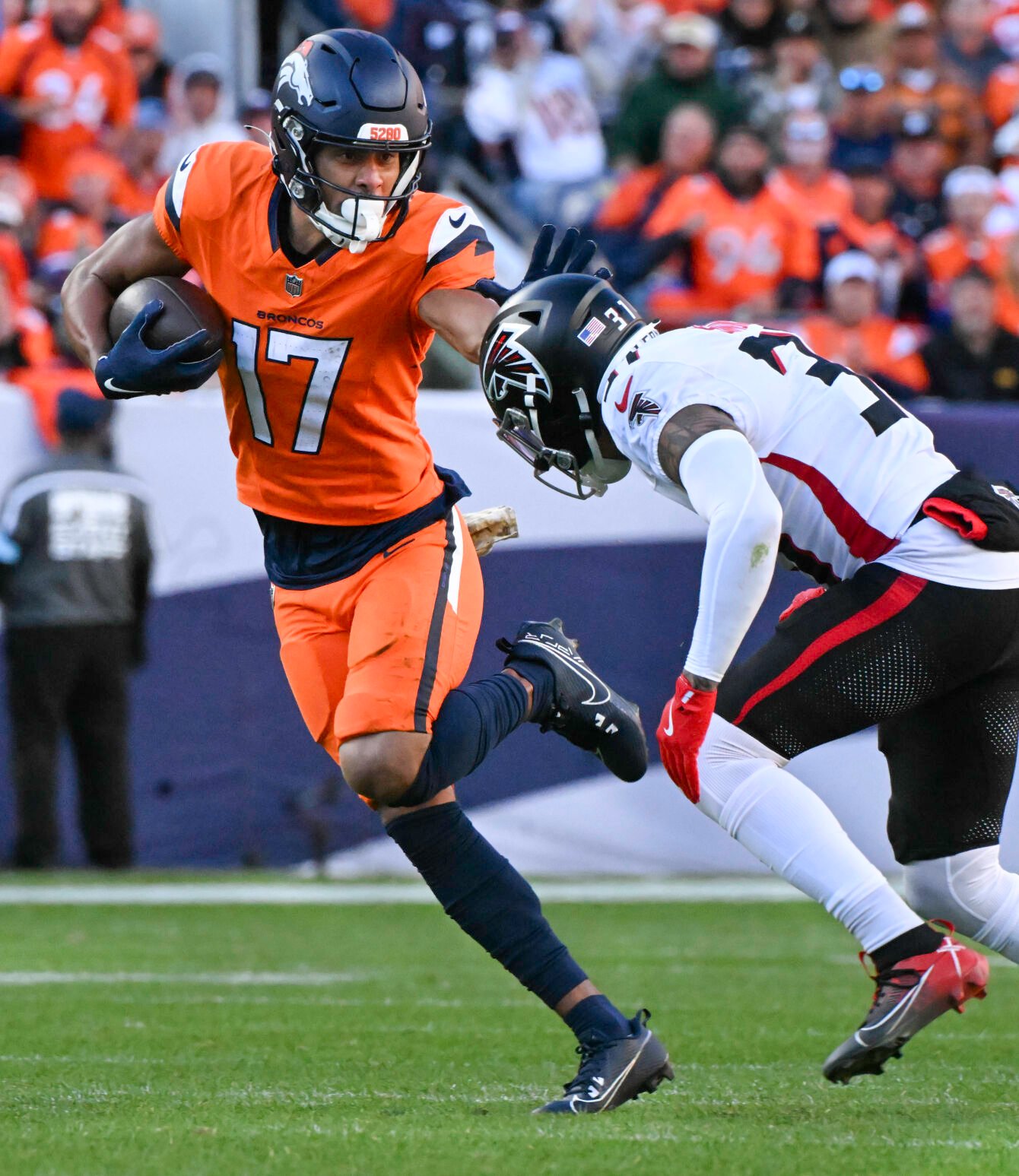 Denver Broncos wide receiver Devaughn Vele (17) stiff arms Atlanta Falcons safety Justin Simmons (31) during the second quarter of a game at Empower Field at Mile High on Sunday, Nov. 17, 2024. The Broncos defeated the Falcons 38-6. (Jerilee Bennett,The Gazette)