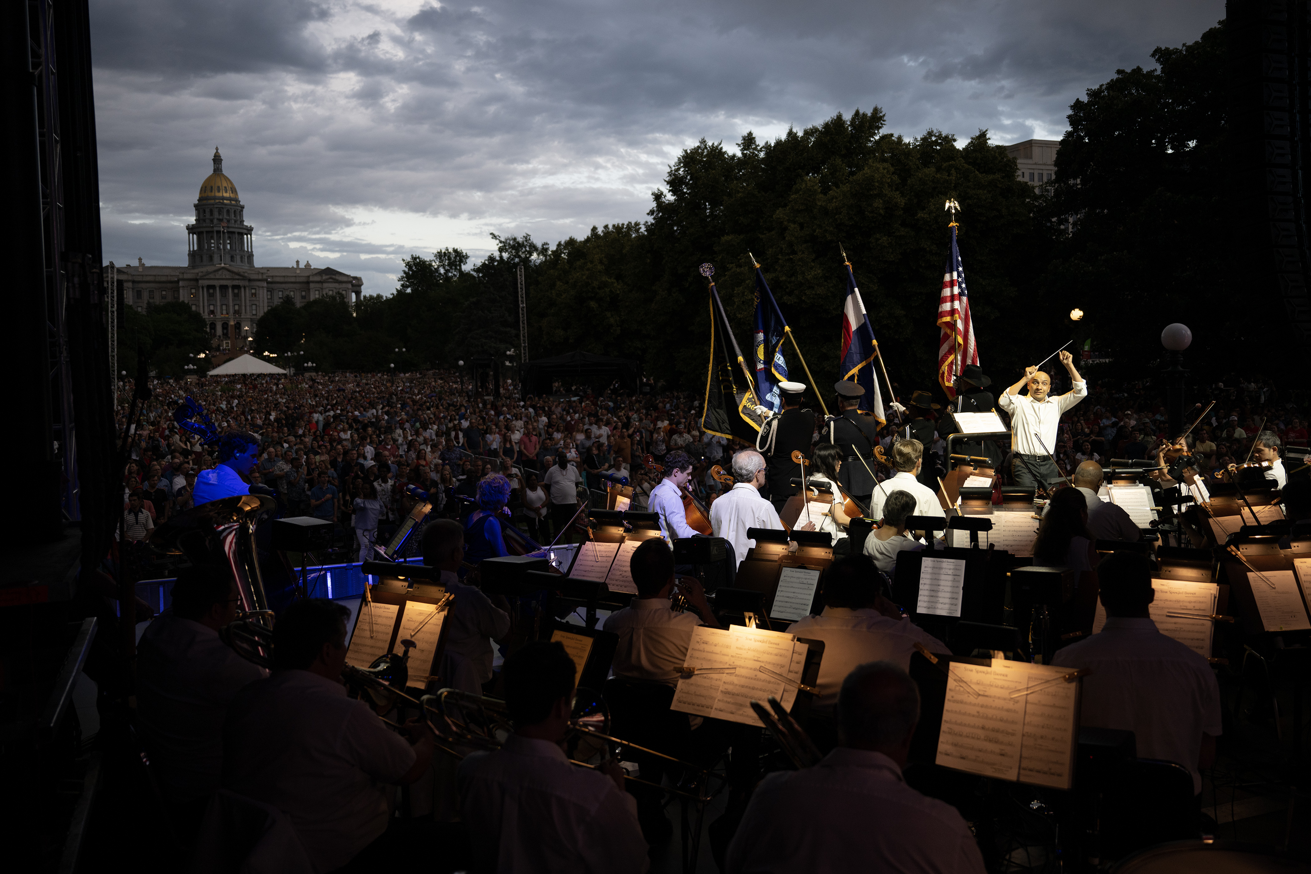 Colorado Symphony resident conductor Christopher Dragon conducts while color guards present the flags on stage during Denver’s Independence Eve celebration on Monday, July 3, 2023, at Civic Center Park in Denver. (Timothy Hurst/Denver Gazette) (TimHursttim.hurst@gazette.comhttps://secure.gravatar.com/avatar/aca82bd62b4ee425c598527cd6faa1b1?d=mm&r=g)
