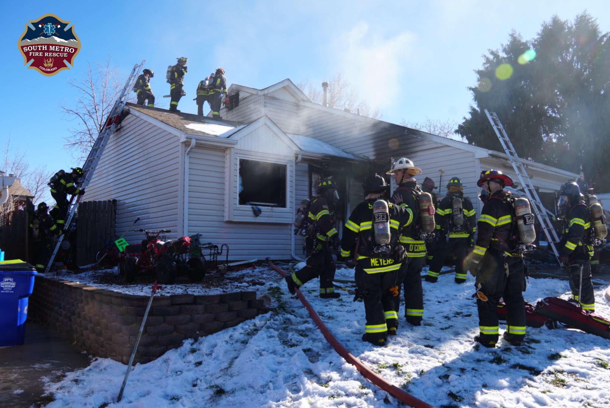Firefighters pour water onto a home where two Arapahoe County Sheriff's Office deputies were treated for injuries after they saved two children from the backyard of a home along the 4800 block of S Gibraltar Ln. in Centennial, Colorado on Sunday, Dec. 1. (Courtesy photo, South Metro Fire Rescue)