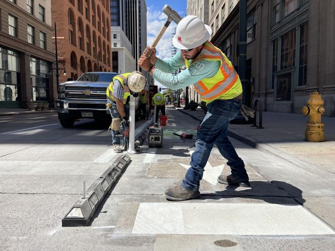 Workers install a bike lane along 17th St. in downtown Denver (copy)