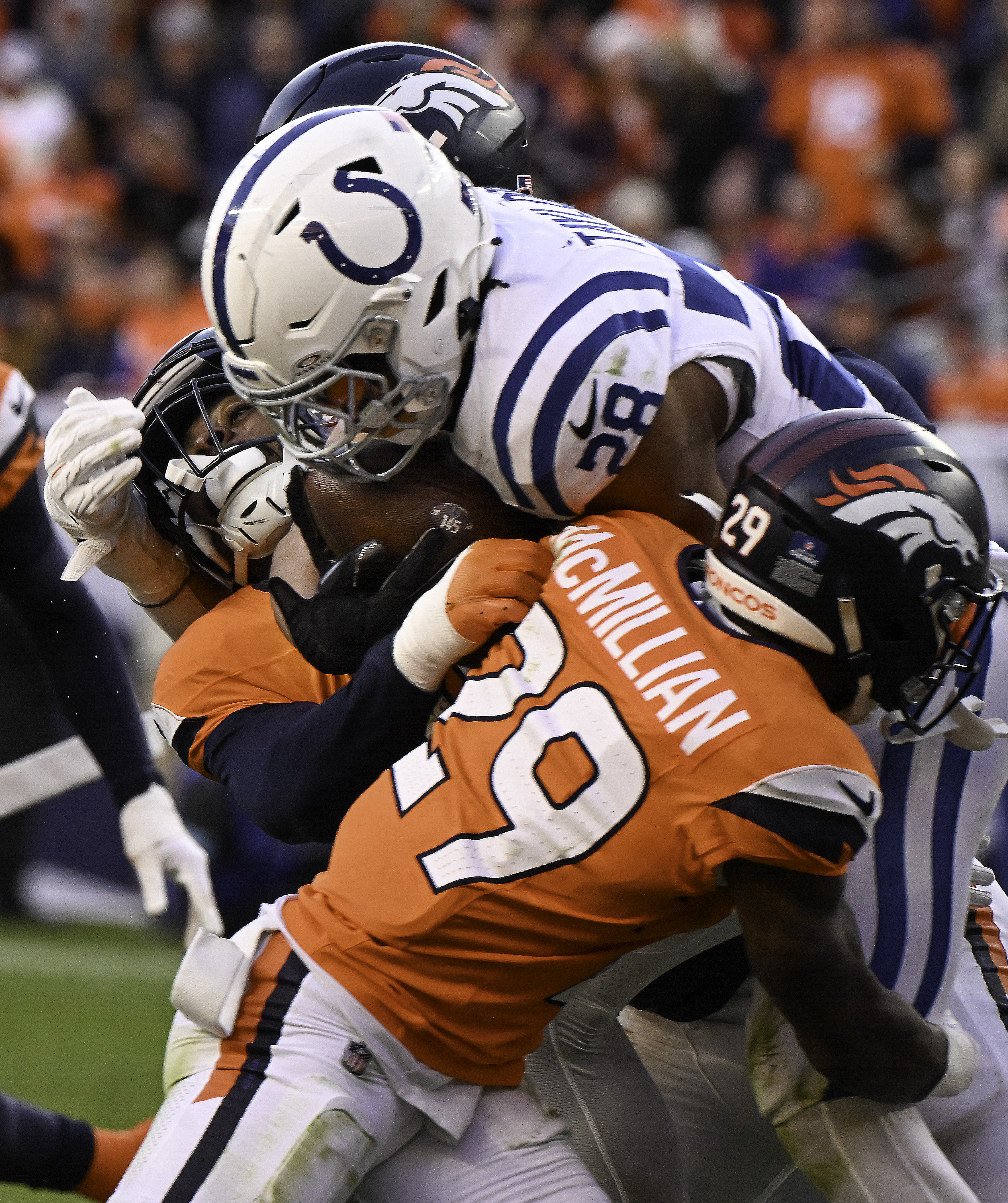 Denver Broncos cornerback Ja'Quan McMillian (29) tackles Indianapolis Colts running back Jonathan Taylor (28) during a game against the Colts. The Broncos defeated the Colts 31-13 at Empower Field at Mile High on Sunday, Dec. 15, 2024. (Jerilee Bennett,The Gazette)