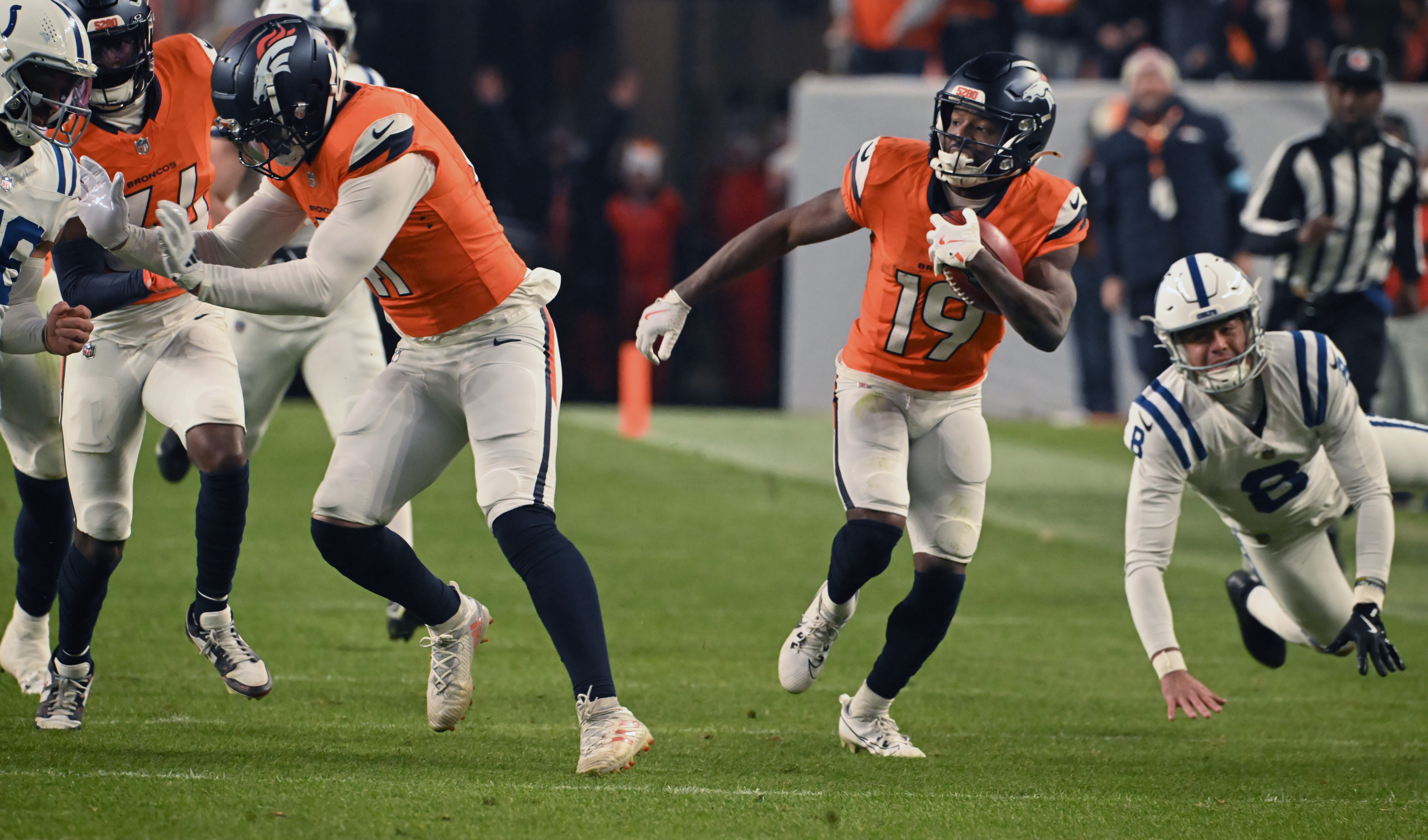 Denver Broncos linebacker Drew Sanders (41) blocks for Denver Broncos wide receiver Marvin Mims Jr. (19) while he is returning a punt for 61 yards during the second half of a game against the Colts. The Broncos defeated the Colts 31-13 at Empower Field at Mile High on Sunday, Dec. 15, 2024. (Jerilee Bennett,The Gazette)