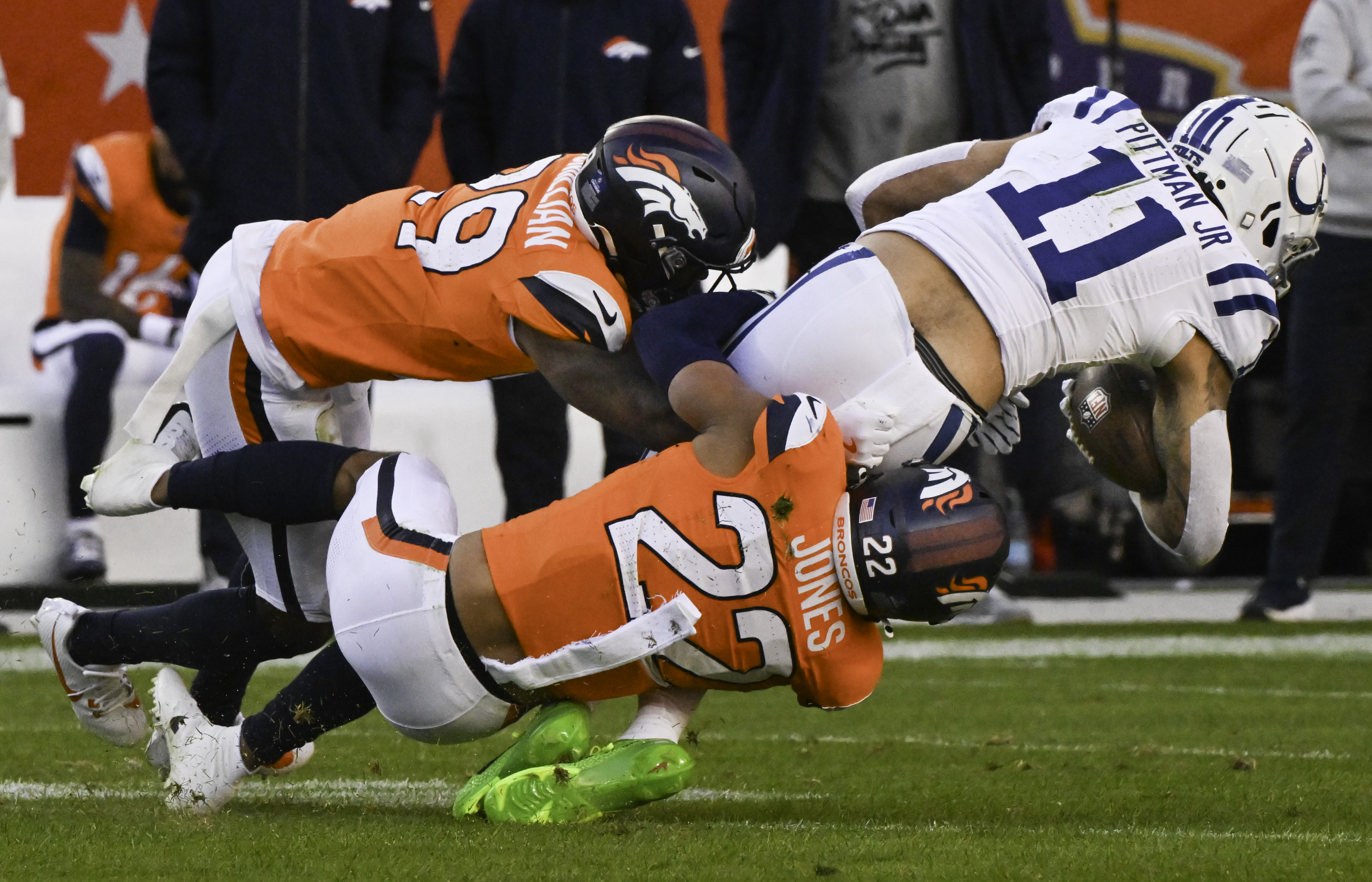 Denver Broncos safety Brandon Jones (22) and Denver Broncos cornerback Ja'Quan McMillian (29) bring down Indianapolis Colts wide receiver Michael Pittman Jr. (11) during a game. The Broncos defeated the Colts 31-13 at Empower Field at Mile High on Sunday, Dec. 15, 2024. (Jerilee Bennett,The Gazette)