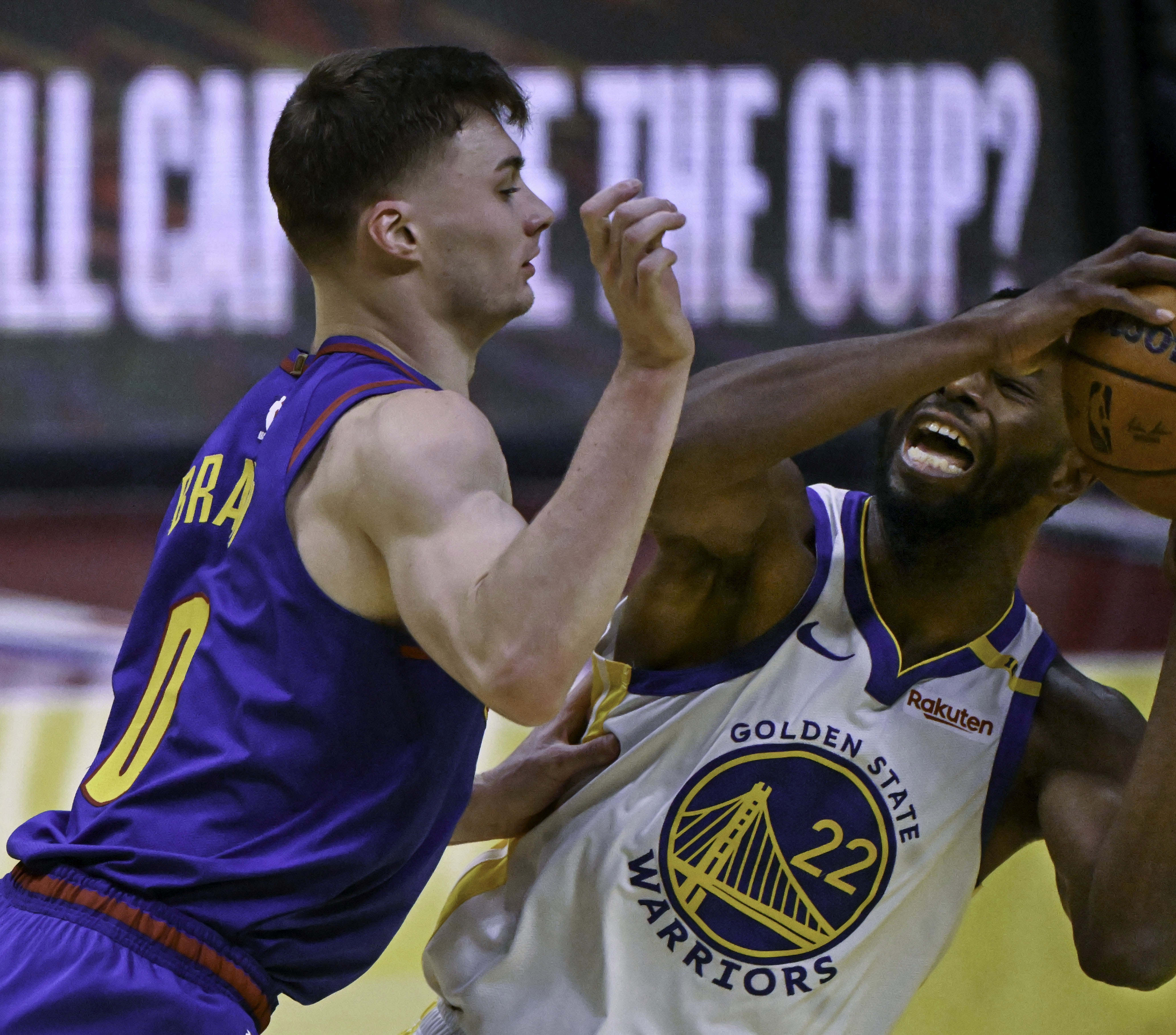 Denver Nuggets guard Christian Braun (0) defends Golden State Warriors forward Andrew Wiggins (22) during an Emirates NBA Cup Group Play game at Ball Arena on Tuesday, Dec. 3, 2024. The Nuggets defeated the Warriors 119-115. (Jerilee Bennett,The Gazette)
