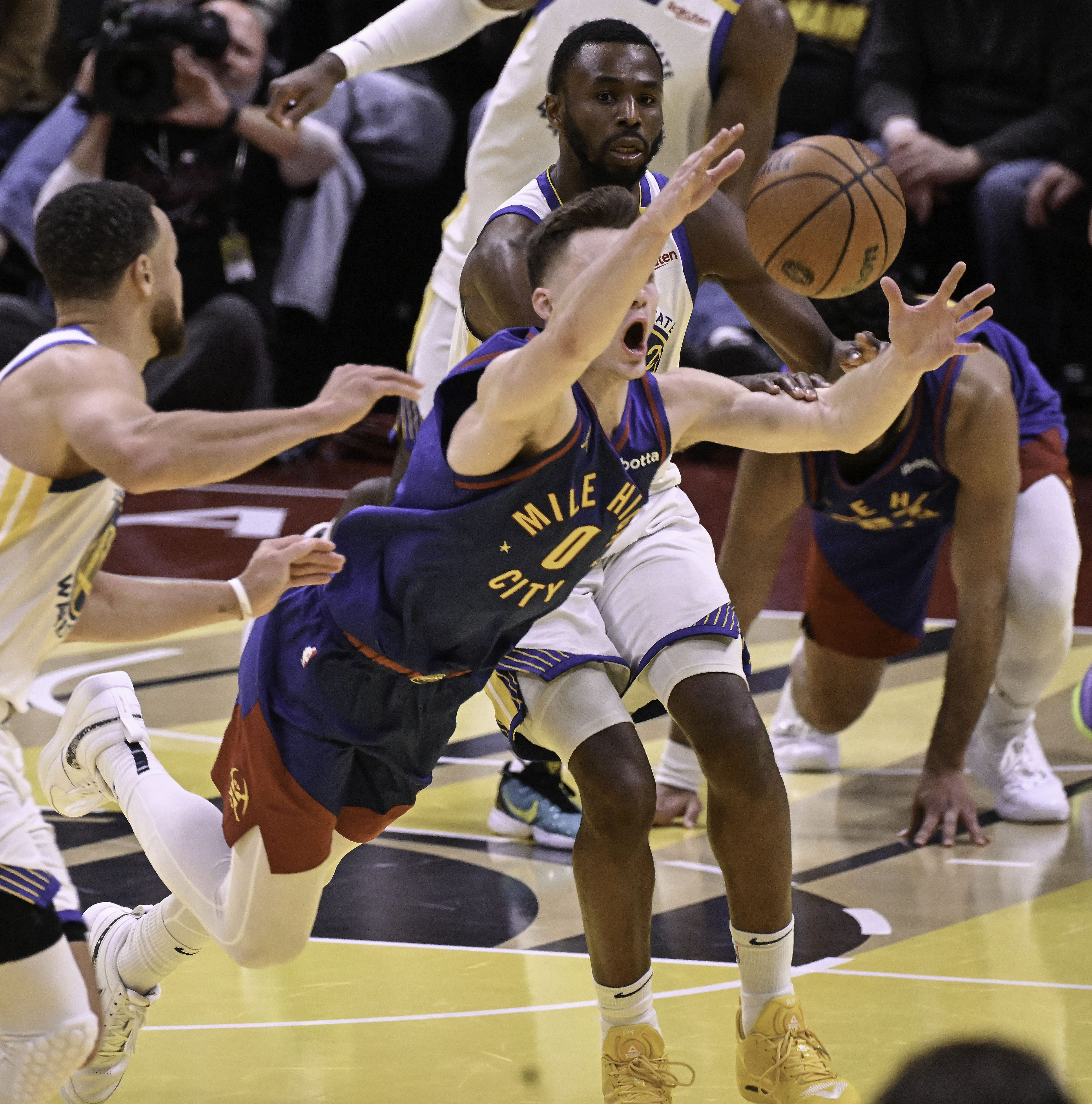 Denver Nuggets guard Christian Braun (0) makes a heroic dive for the ball to keep it away from Golden State Warriors guard Stephen Curry (30) during the fourth quarter of an Emirates NBA Cup Group Play game at Ball Arena on Tuesday, Dec. 3, 2024. (Jerilee Bennett,The Gazette)
